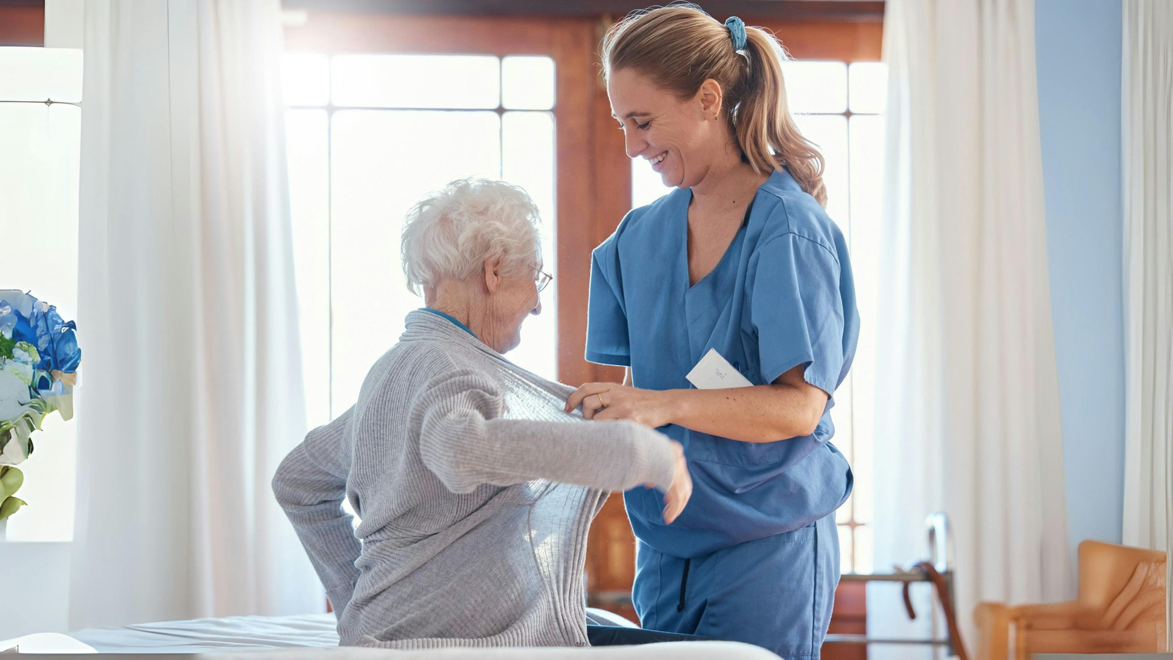 Préposée Aidexpress aidant une personne âgée à s’habiller en toute sécurité, avec respect et bienveillance. 