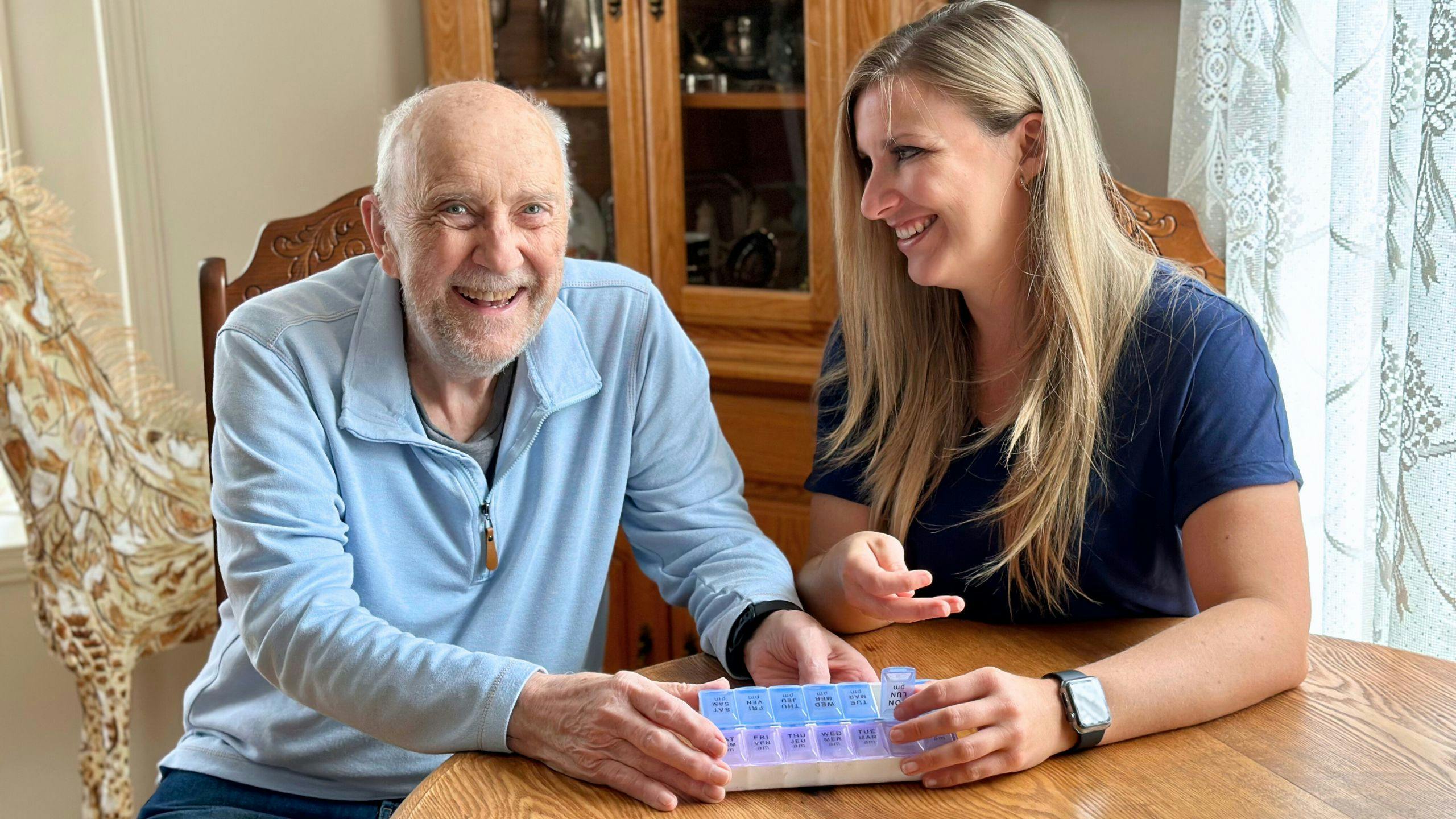 Une préposée Aidexpress en soins à domicile assiste une personne âgée lors de la prise de médicaments, illustrant l’accompagnement sécuritaire et le soutien aux aînés.