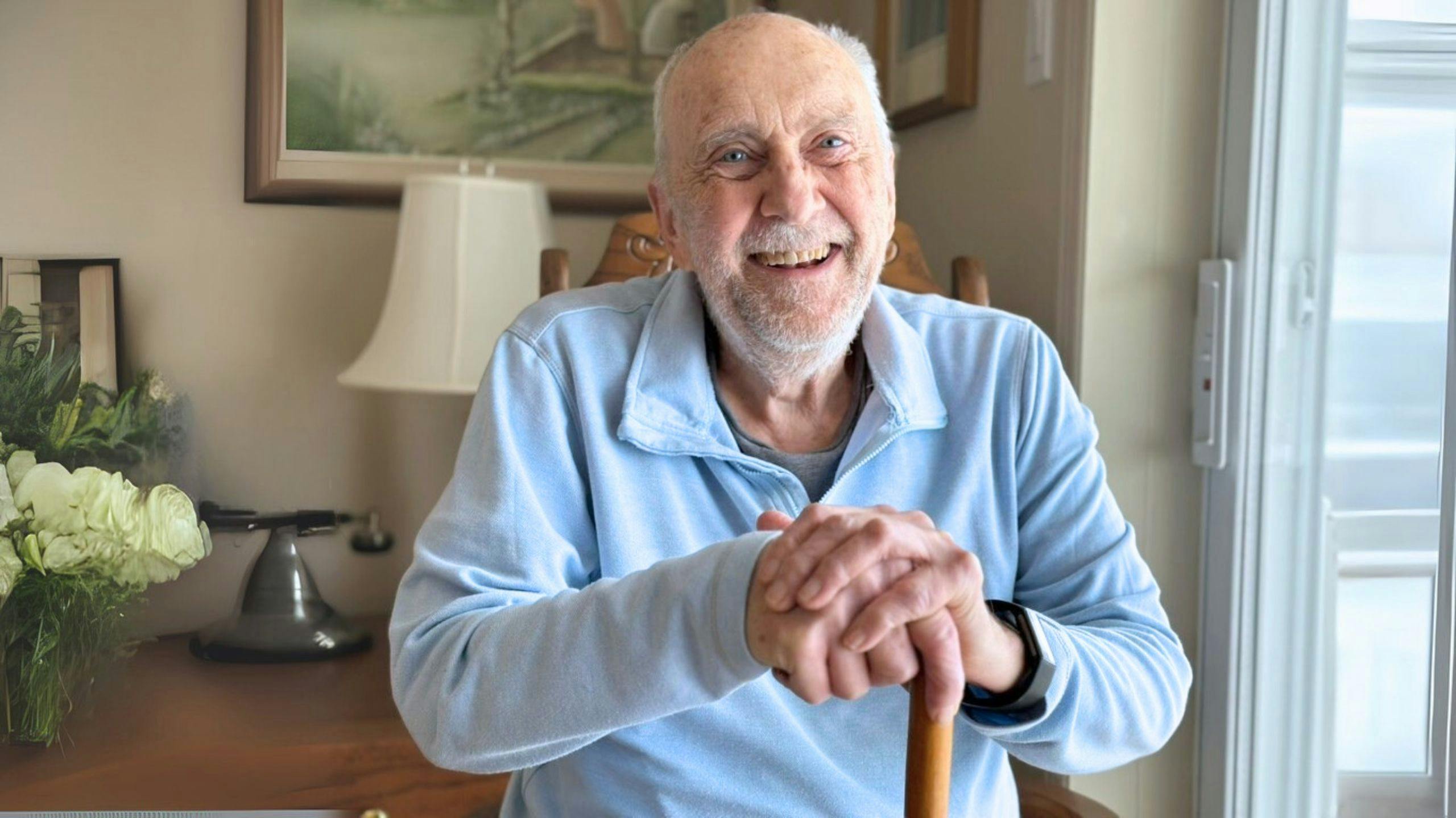 Homme avec canne, détendu et souriant chez lui, services et soins Aidexpress pour personnes à mobilité réduite, respectueux, bienveillants et personnalisés.