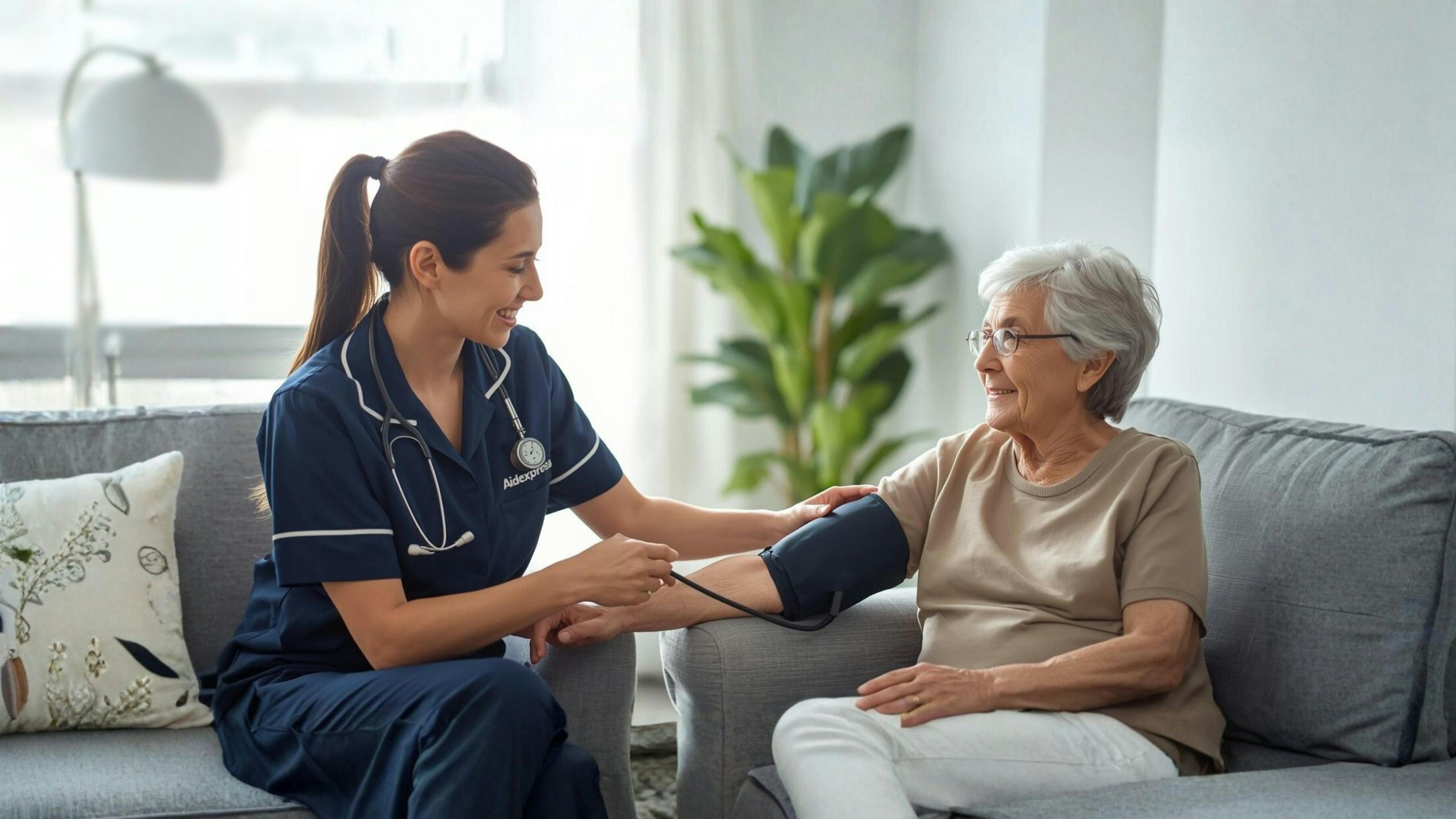 Infirmière à domicile Aidexpress effectue une prise de tension artérielle auprès d’une personne âgée, illustrant les soins infirmiers et le suivi de santé à la maison.