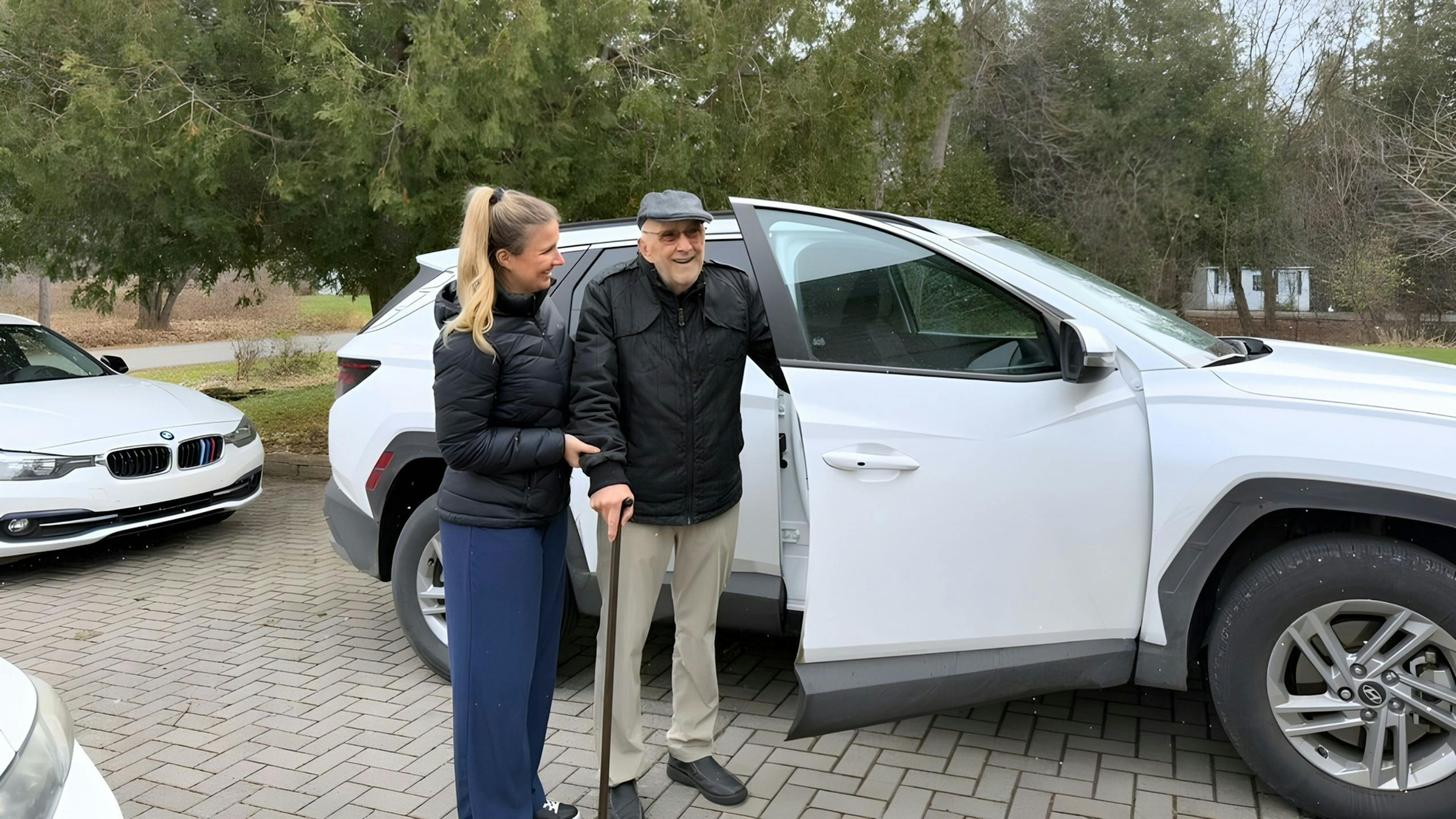 Personne âgée sortant d'une auto avec son aidant d’Aidexpress pour se rendre à son rendez-vous médical.