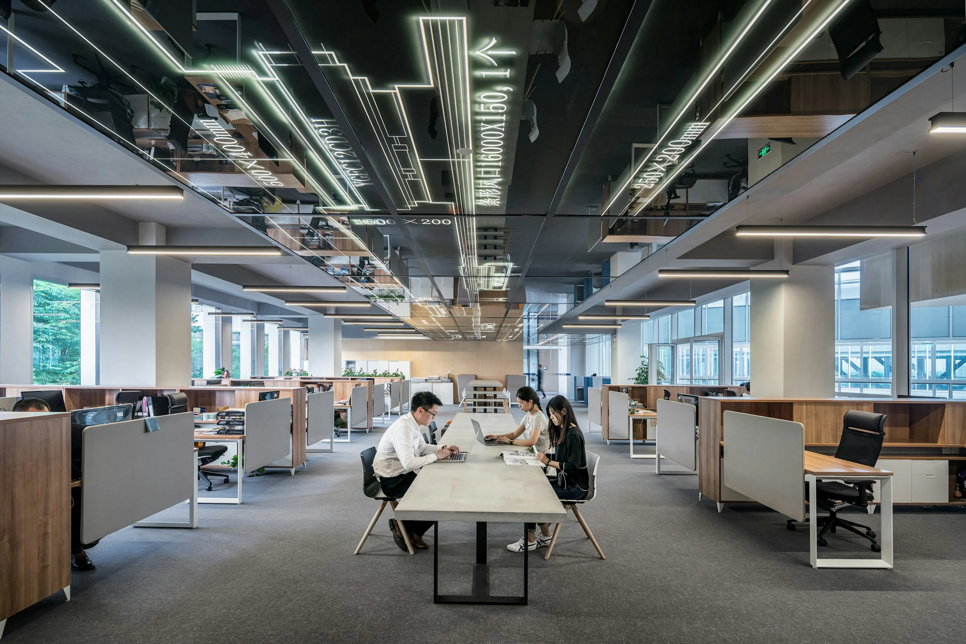 People working around a shared table in a light-filled open office