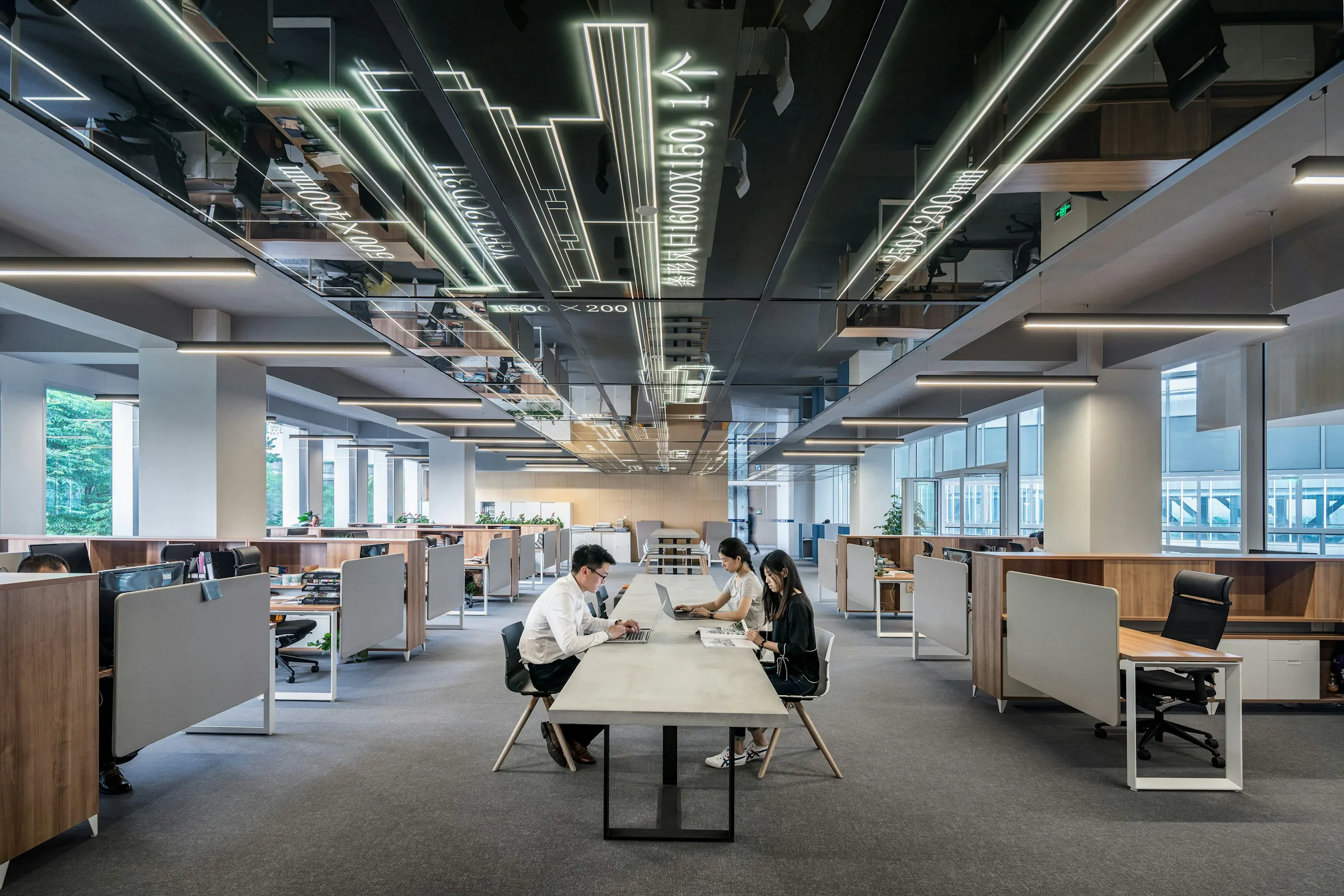 People working around a shared table in a light-filled open office