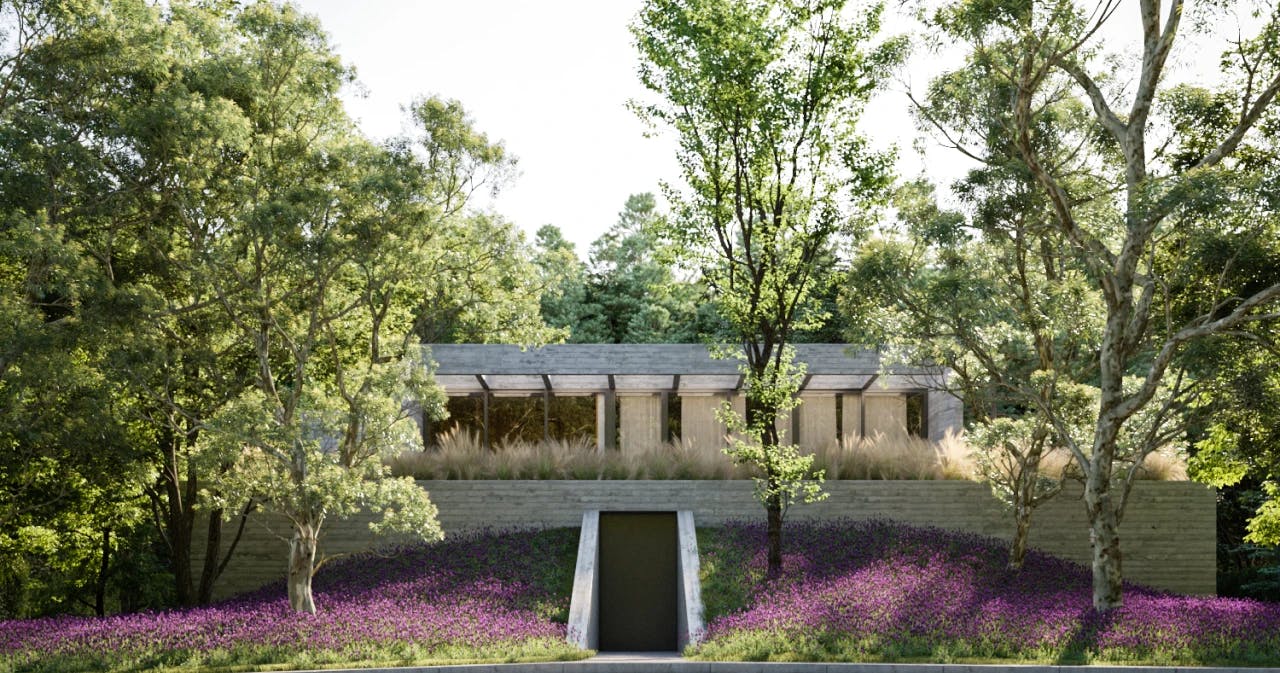 Moderne woning deels verborgen in een groene heuvel, omringd door bomen en paarse bloemenvelden.