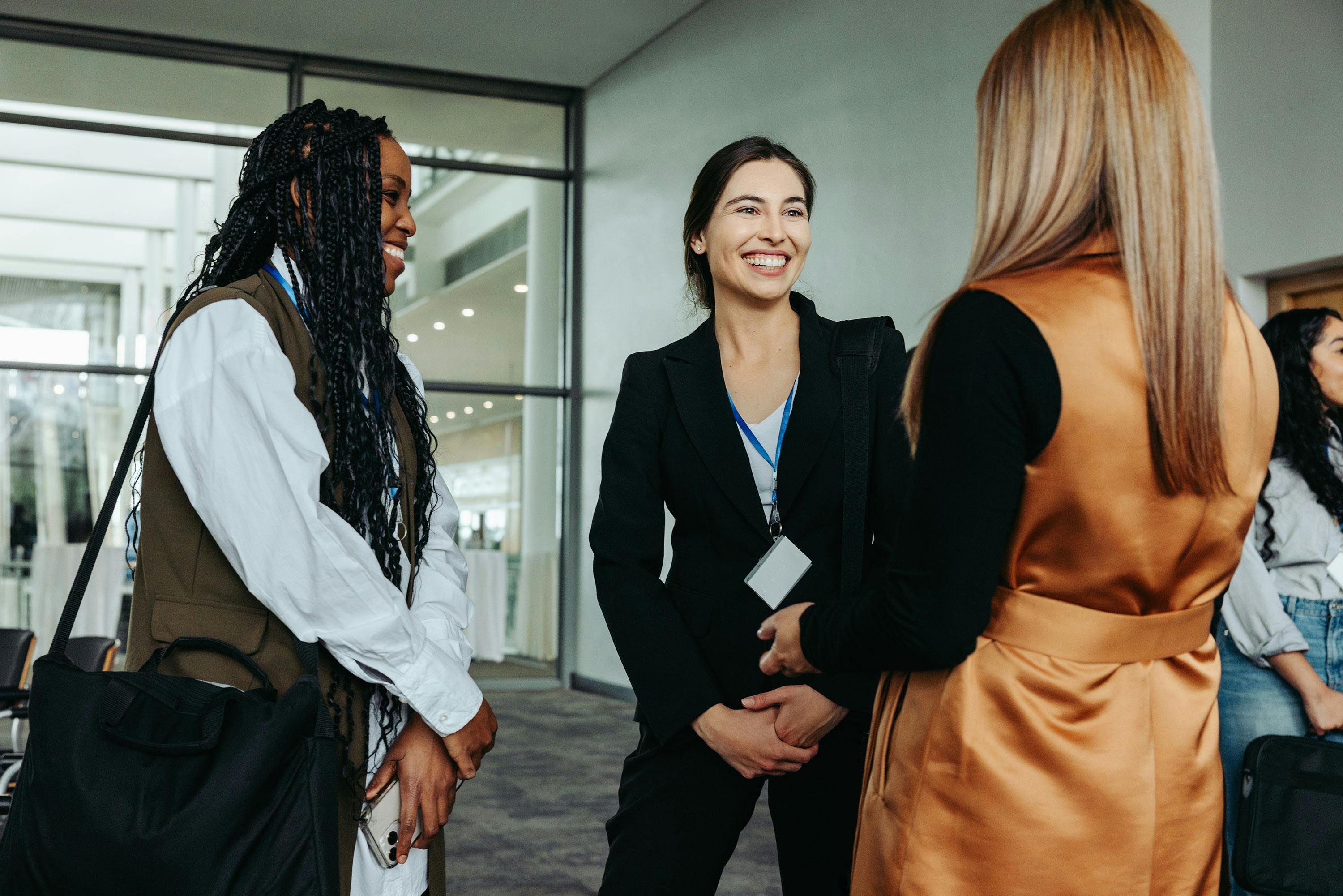 Three women standing outside of a building talking