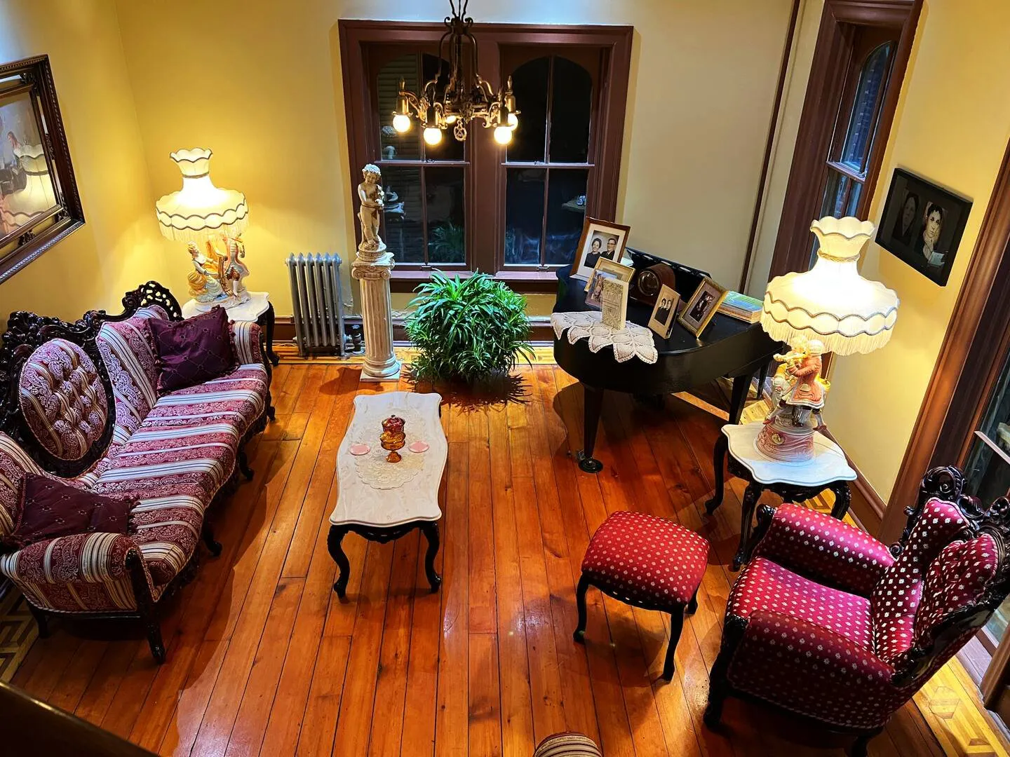 Victorian parlor in the Roff Home in Watseka, Illinois, with carved antique sofas, a chandelier and original wood floors