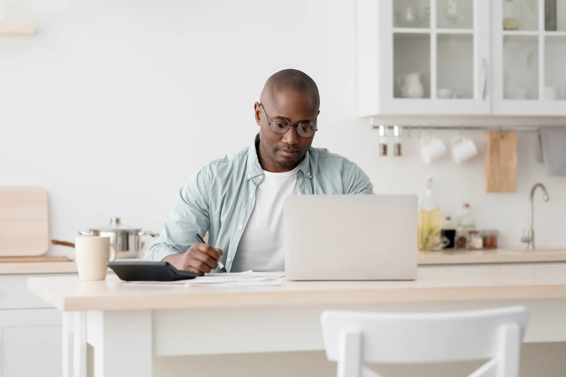 Man calculating taxes and using a laptop.