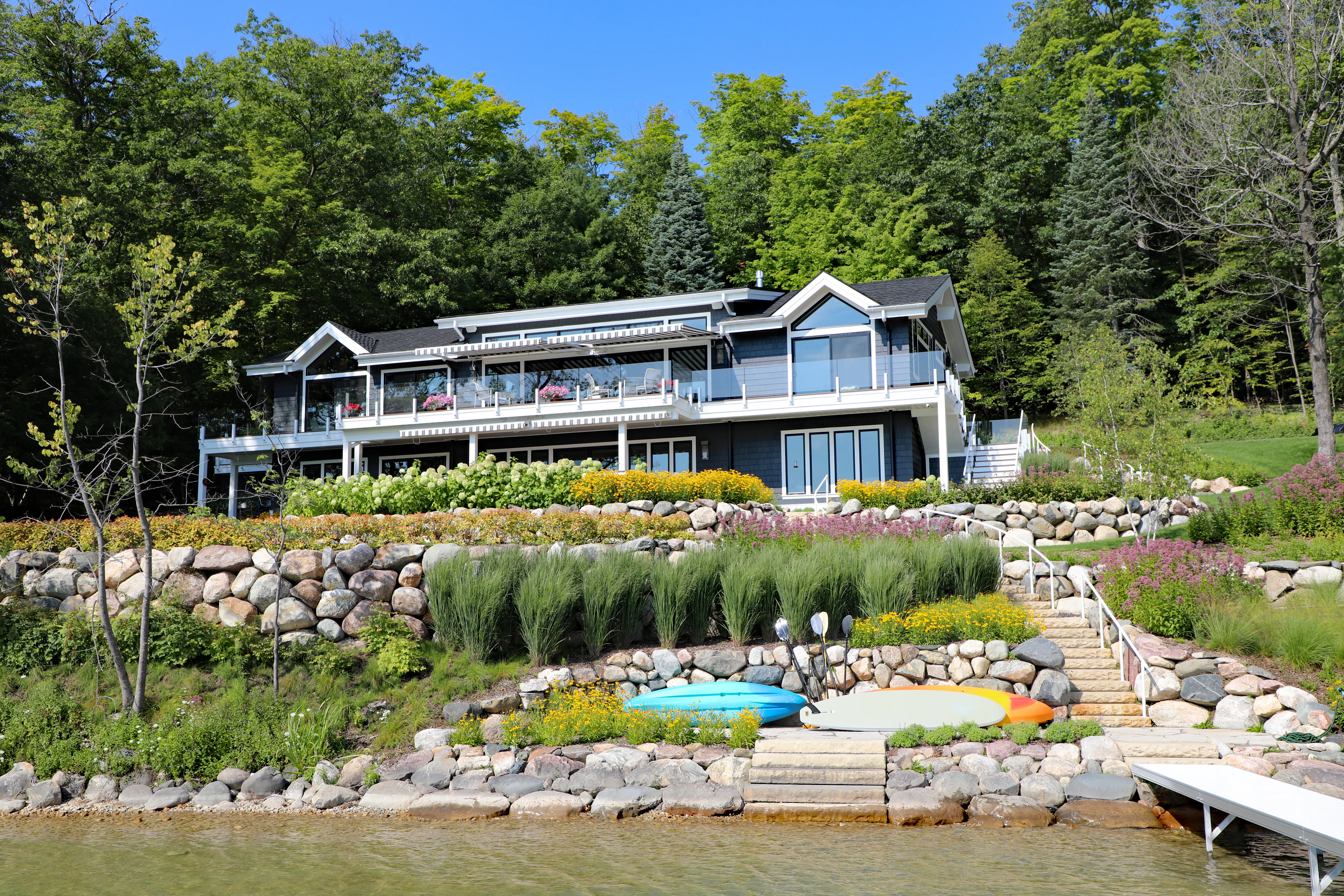 Lake house with nice landscaping in backyard