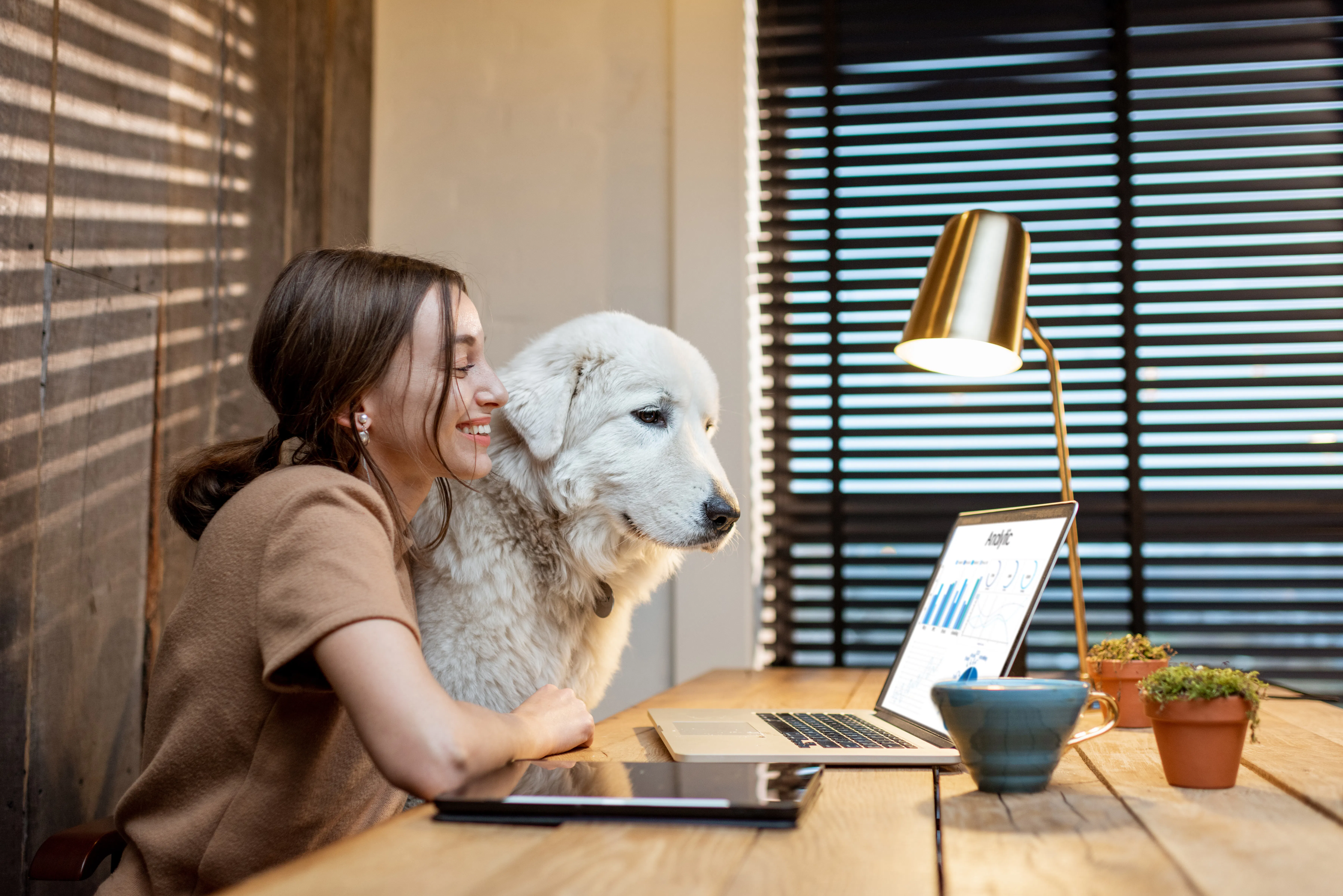 Woman at desk with dog in home office
