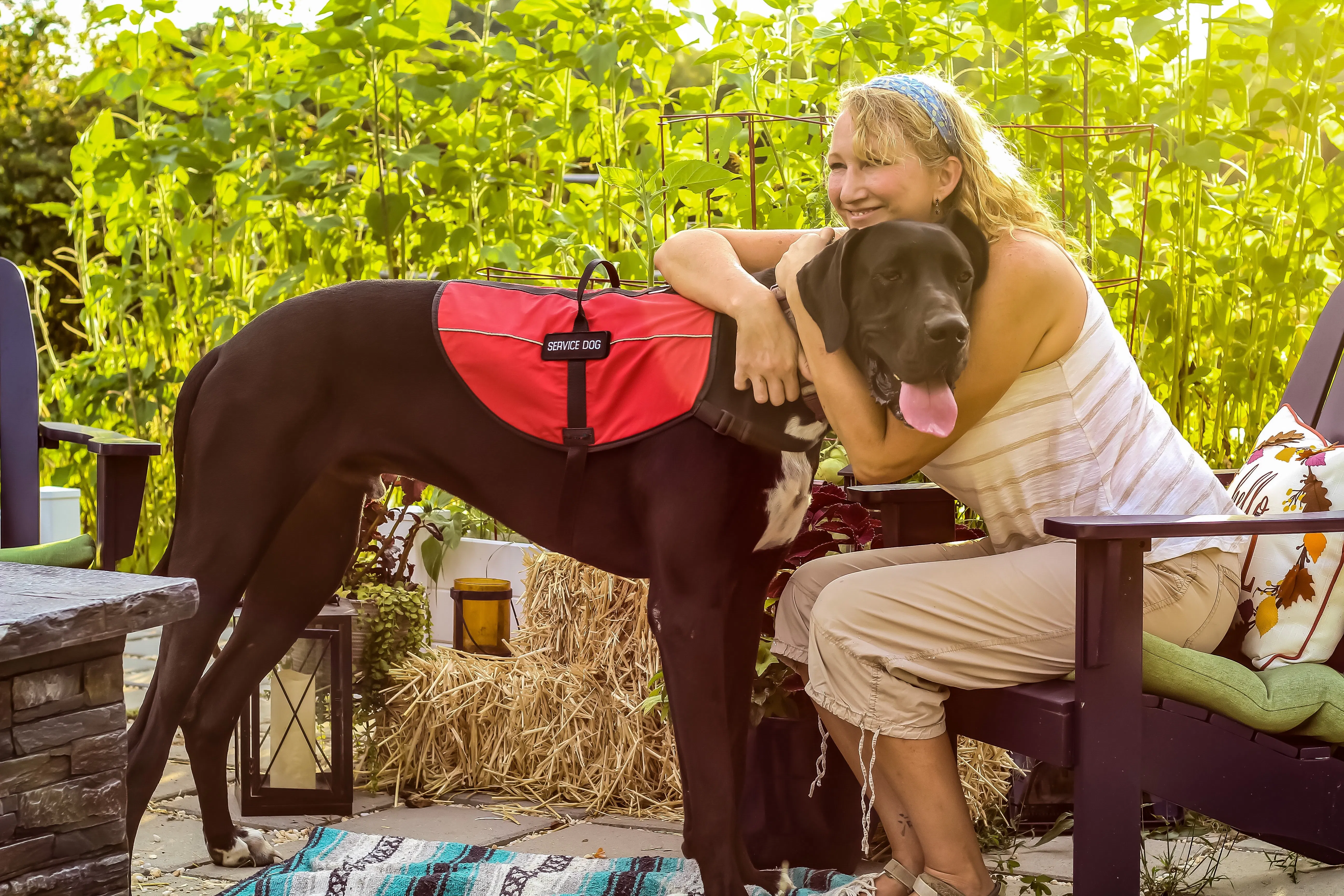 Woman hugging service dog on patio