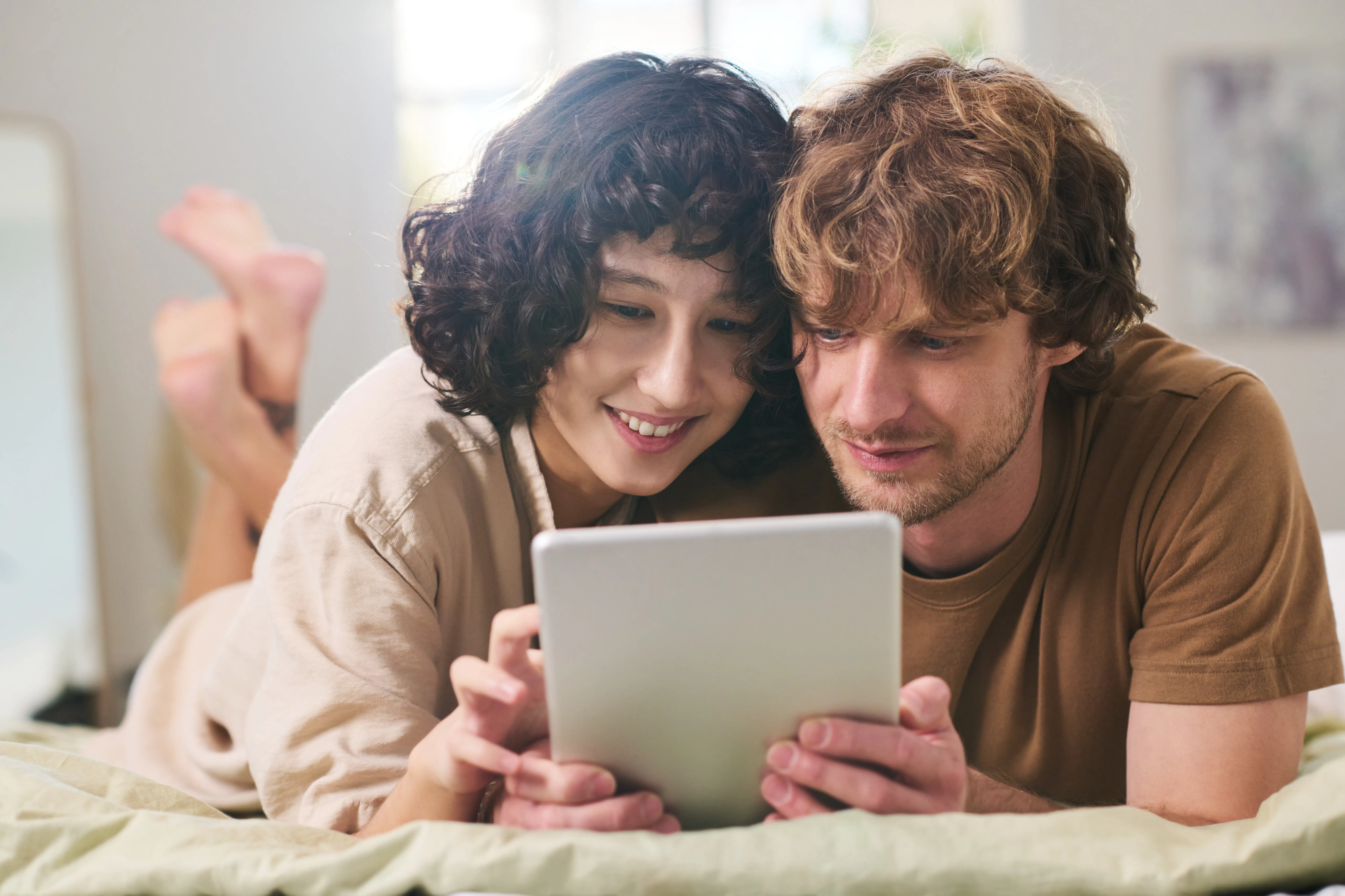 Young affectionate couple looking through online goods