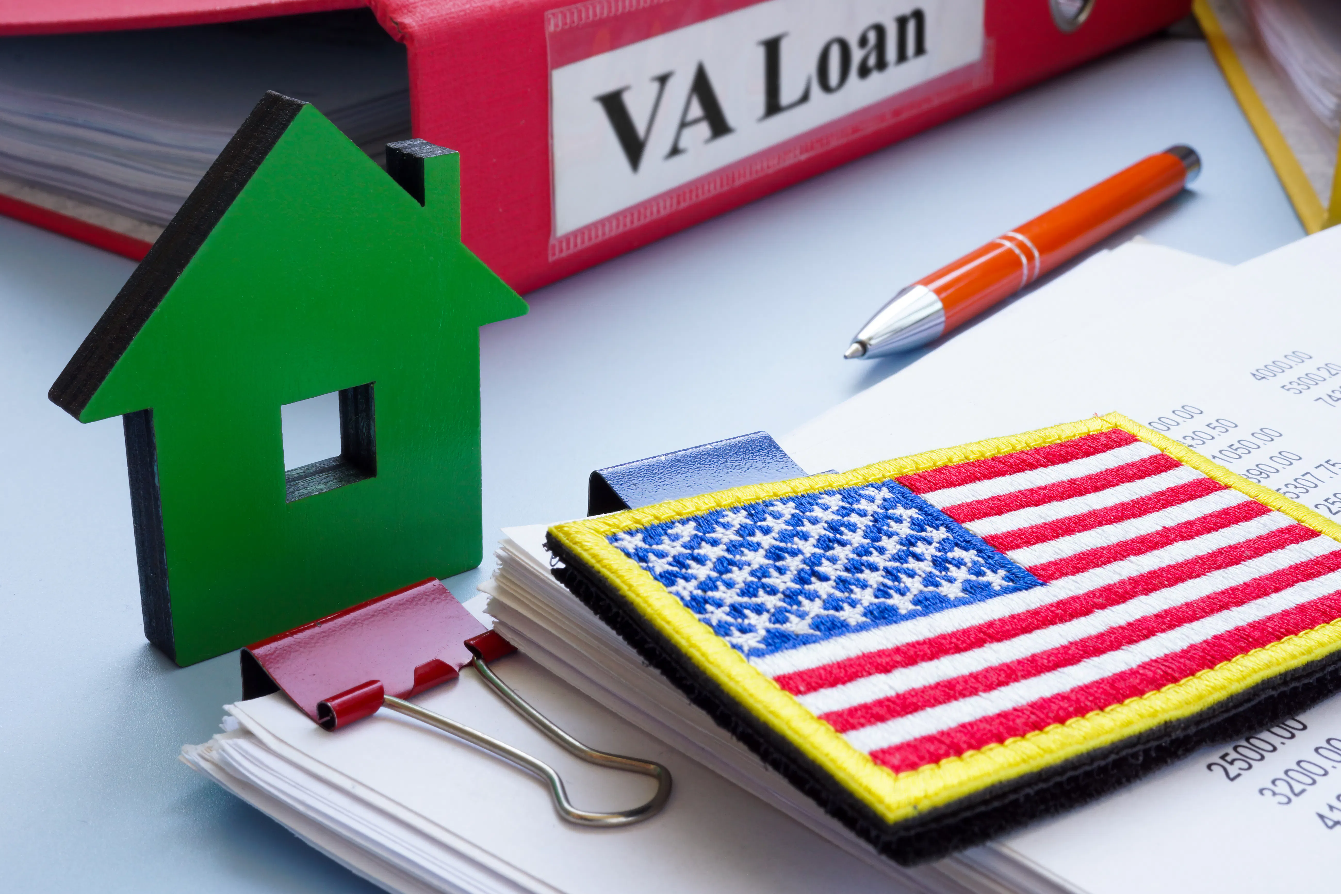 Model of house, flag, and papers with VA loan.