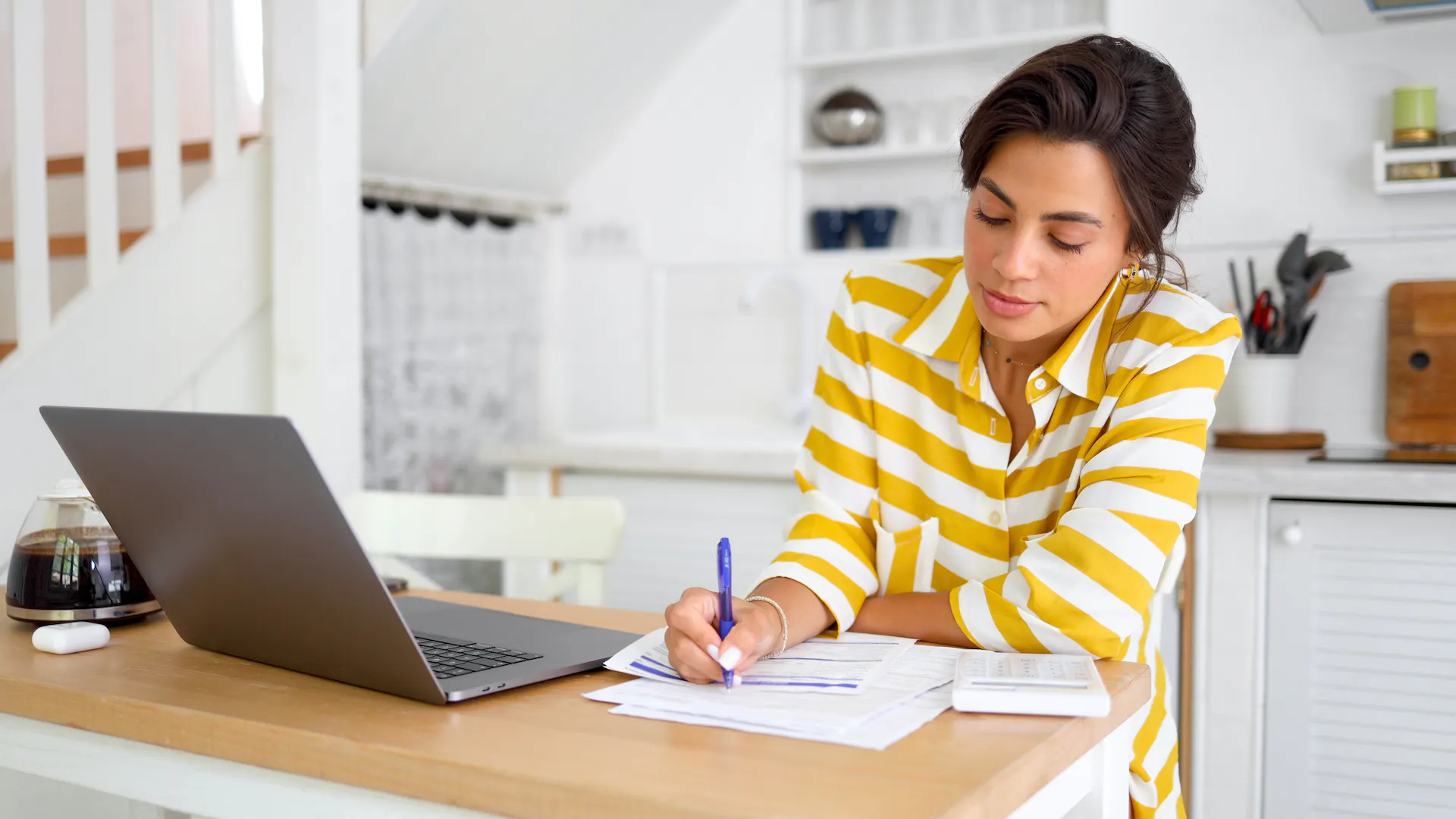 Woman doing tax calculations at home.