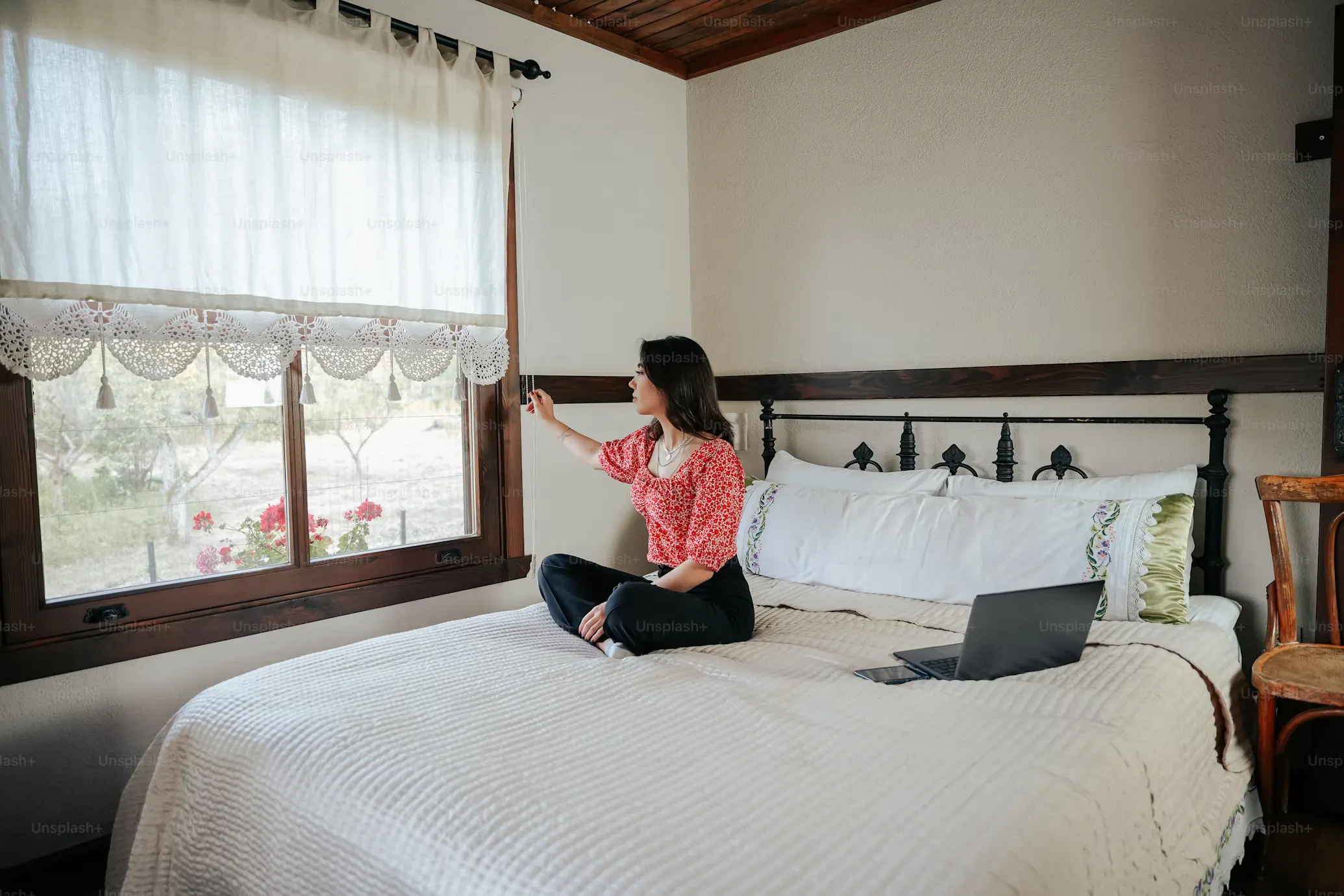 Woman sitting on bed with laptop