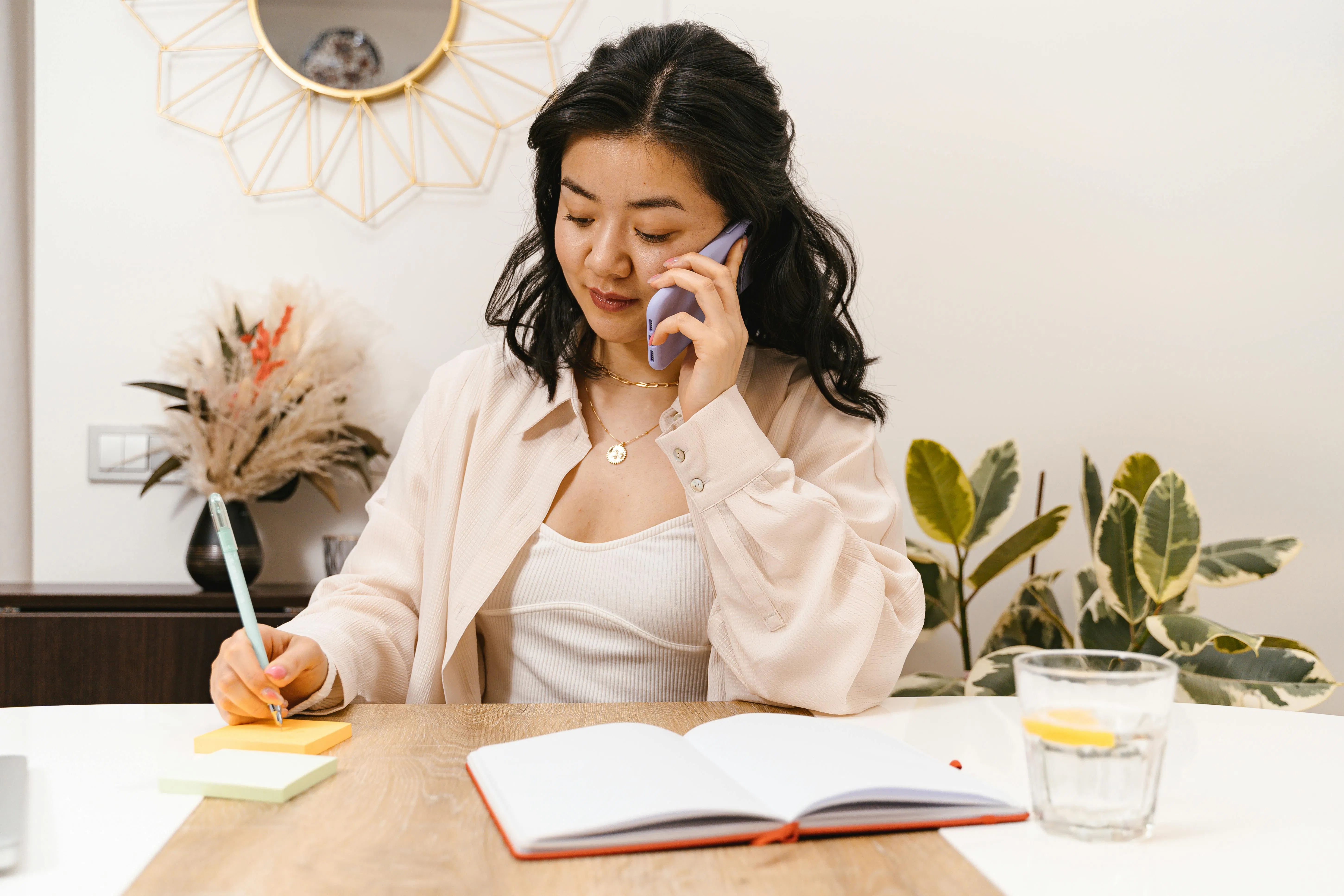 Woman on the phone while taking notes