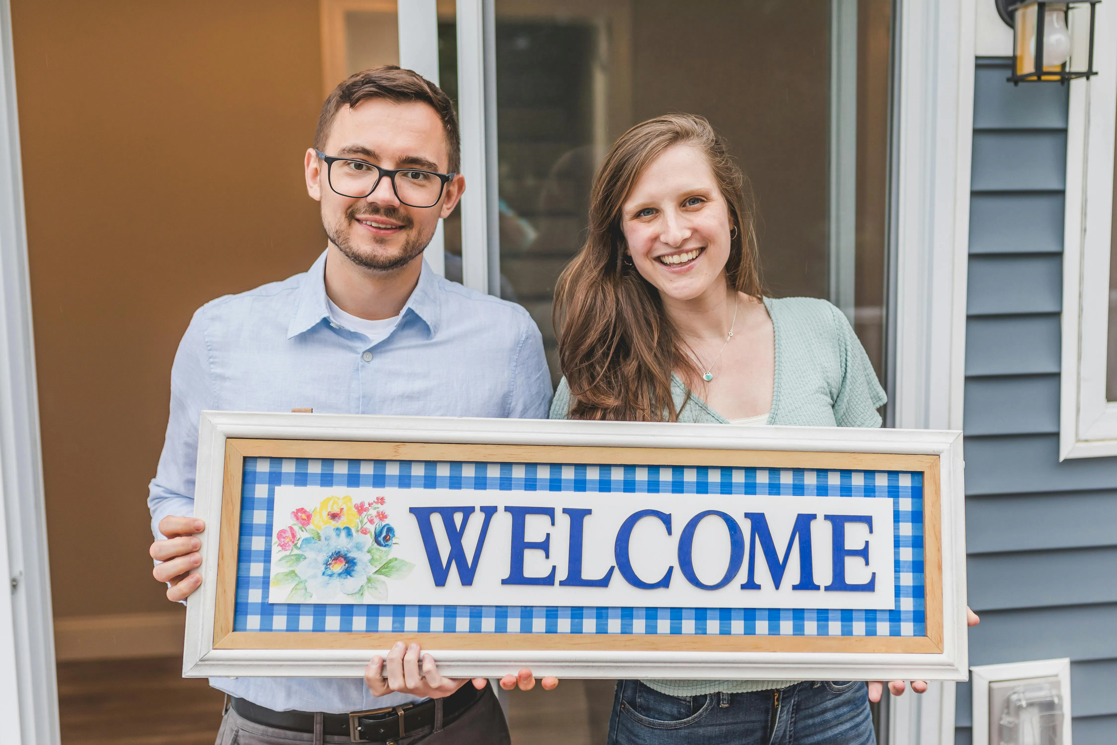 Man and woman holding a welcome sign