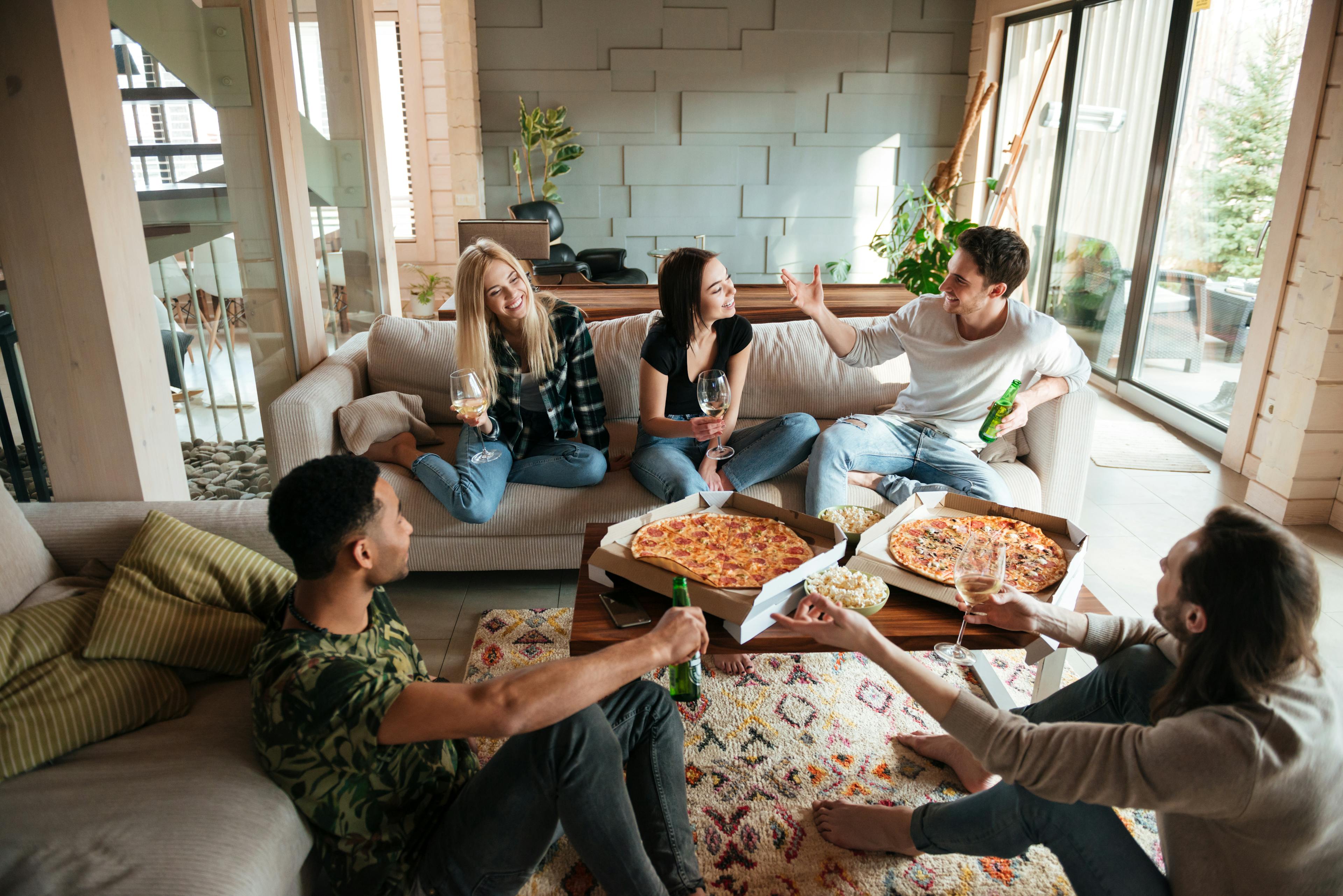 friends eating pizza in living room