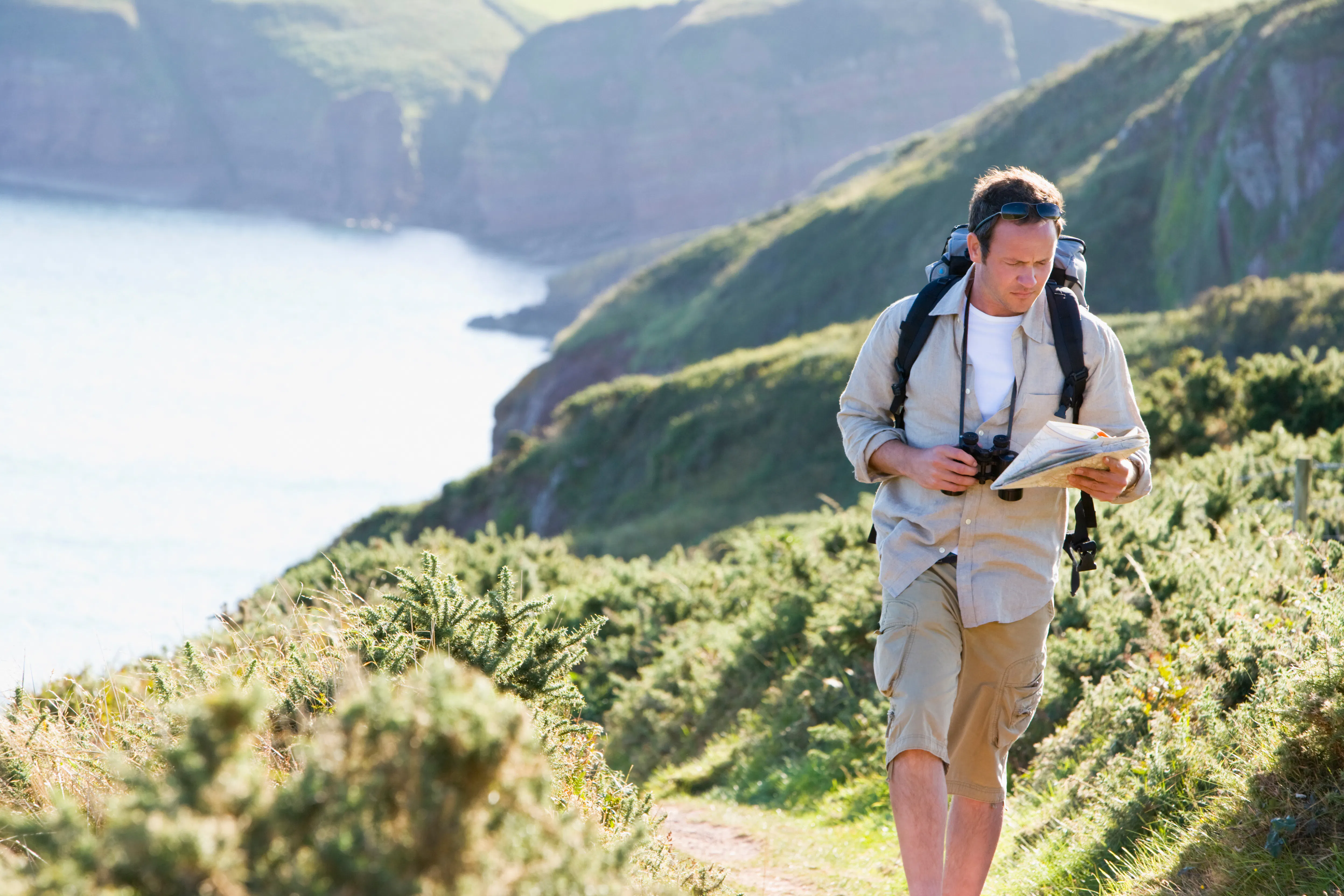 Hiker with binoculars and map