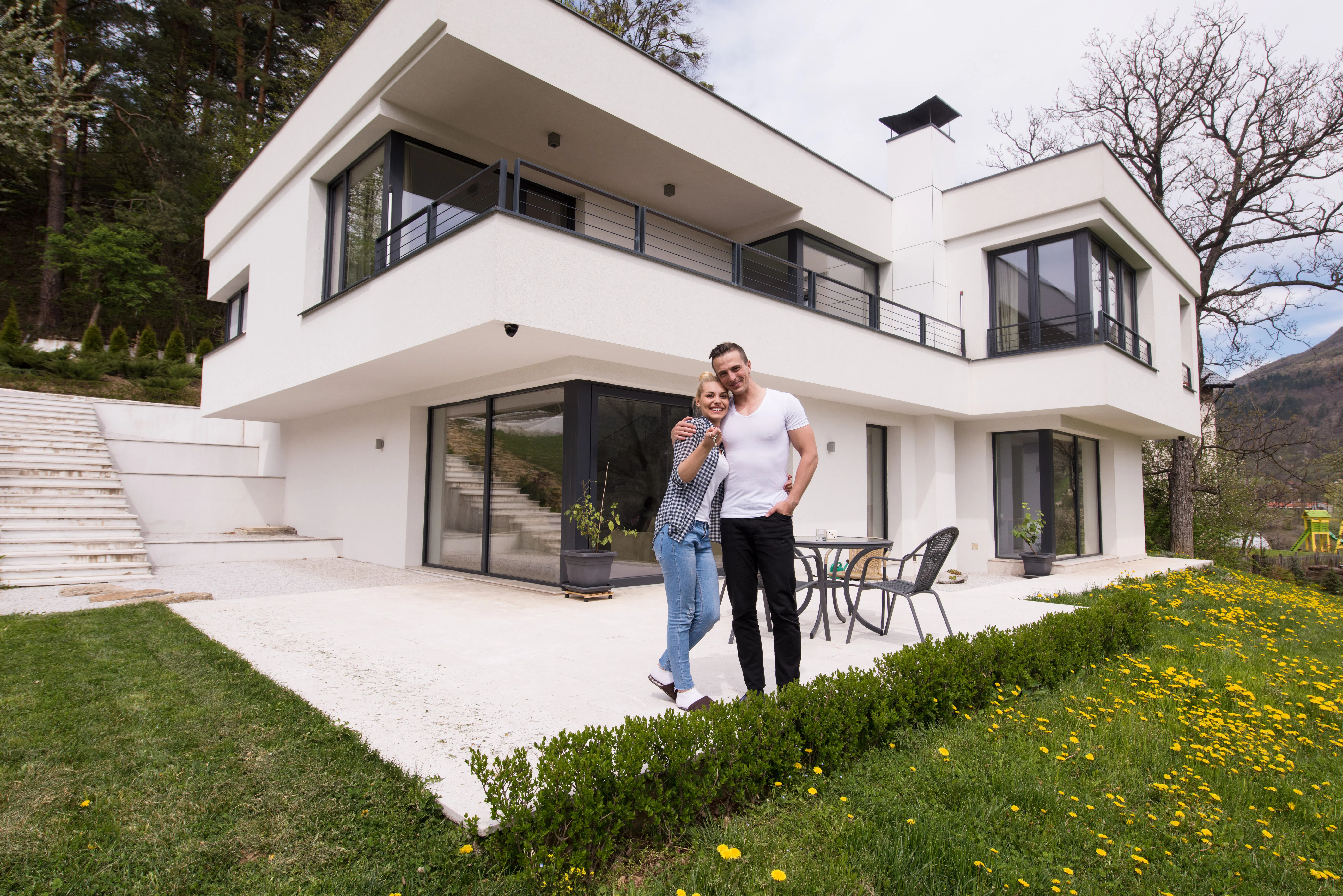 Couple hugging in front of new luxury short-term rental