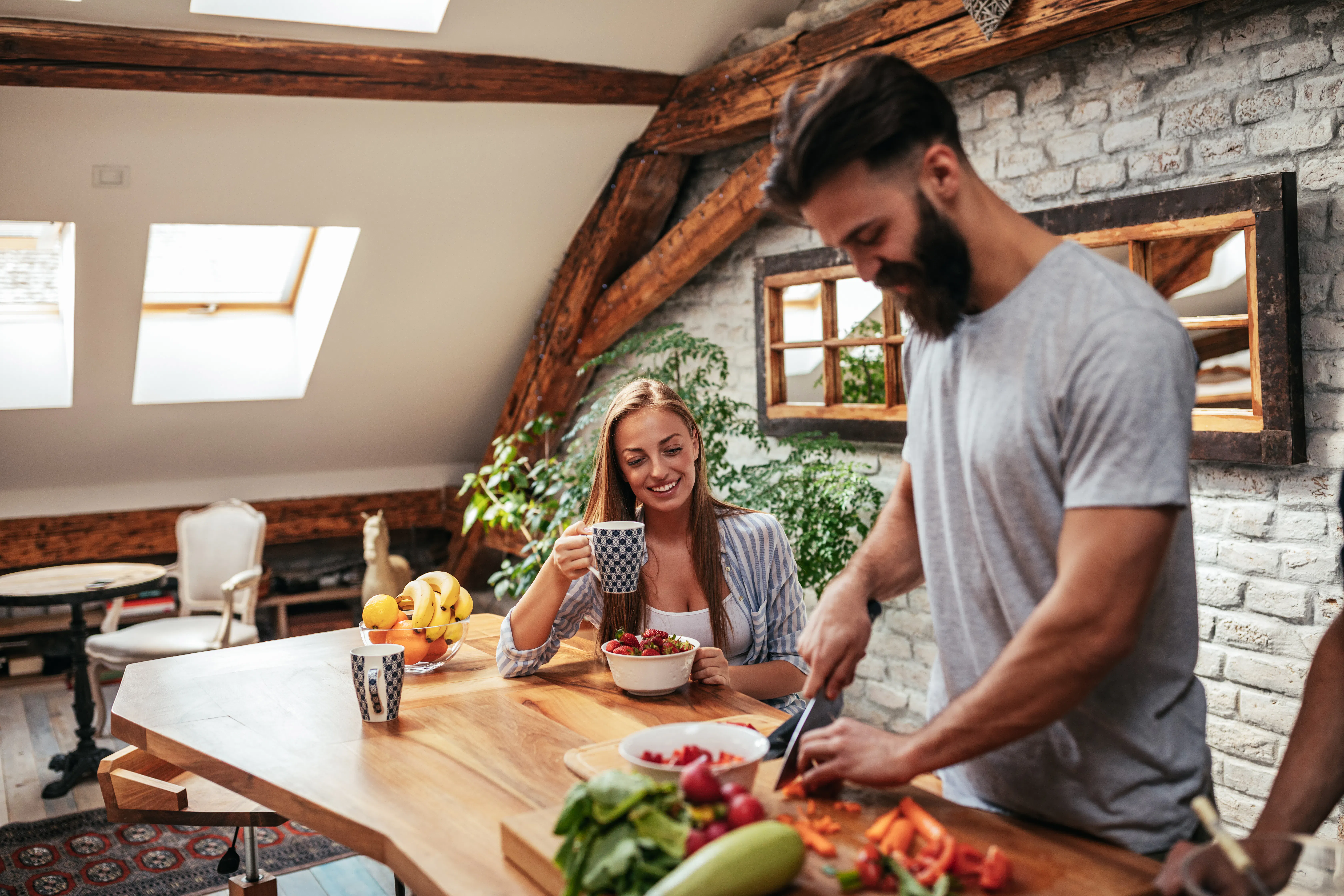 Couple cutting fruits in house