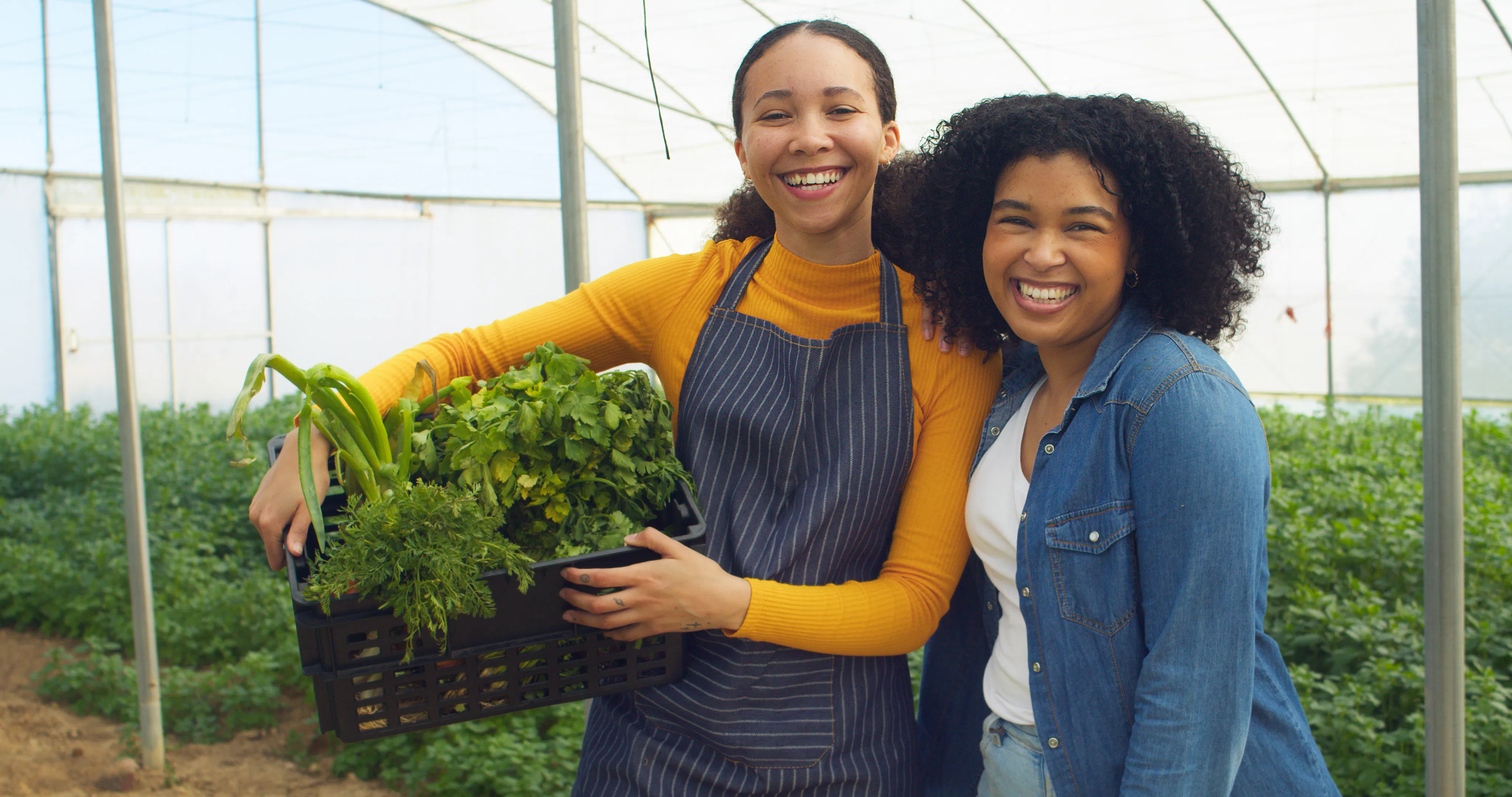 women holding vegetable crate