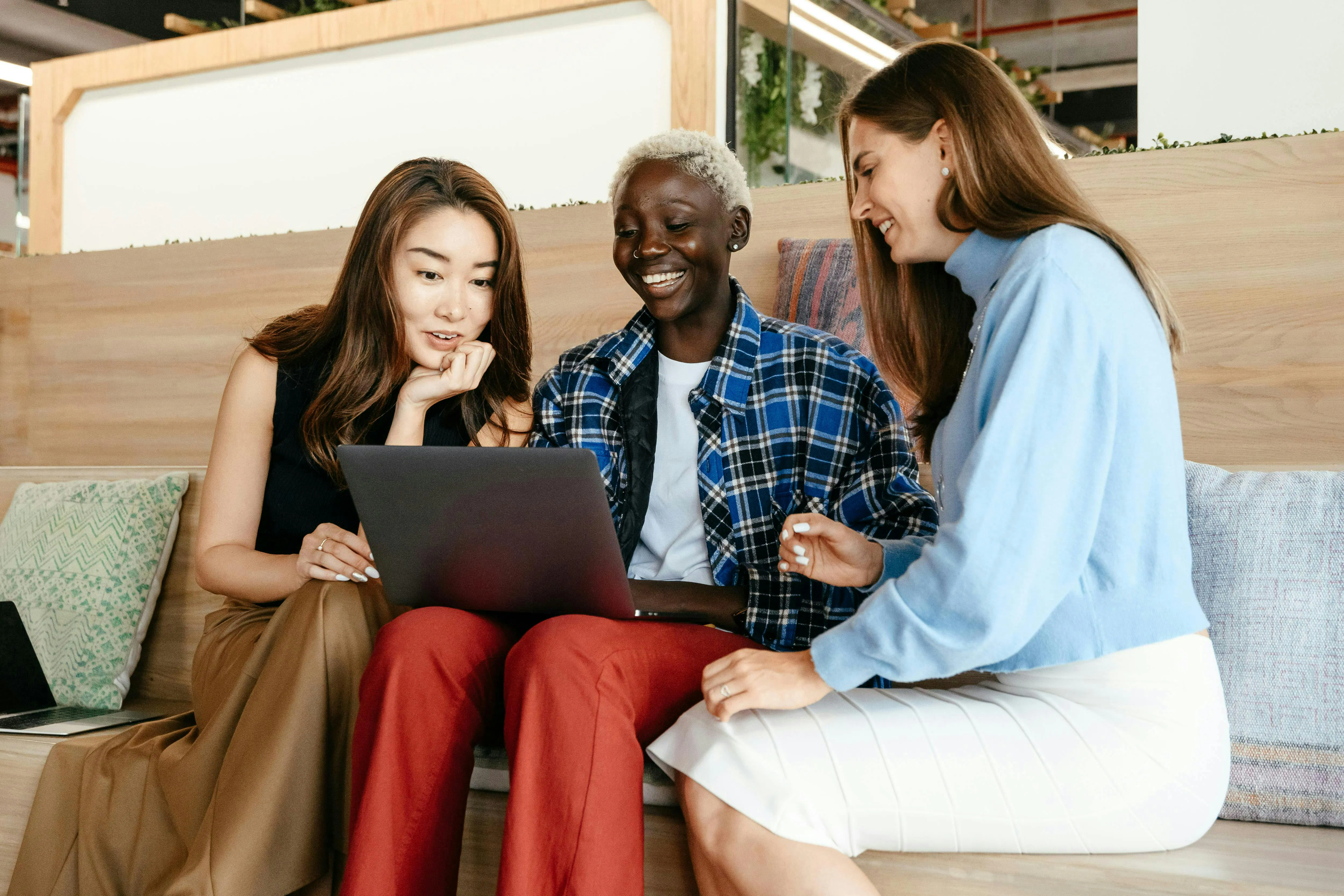 friends gathered around laptop