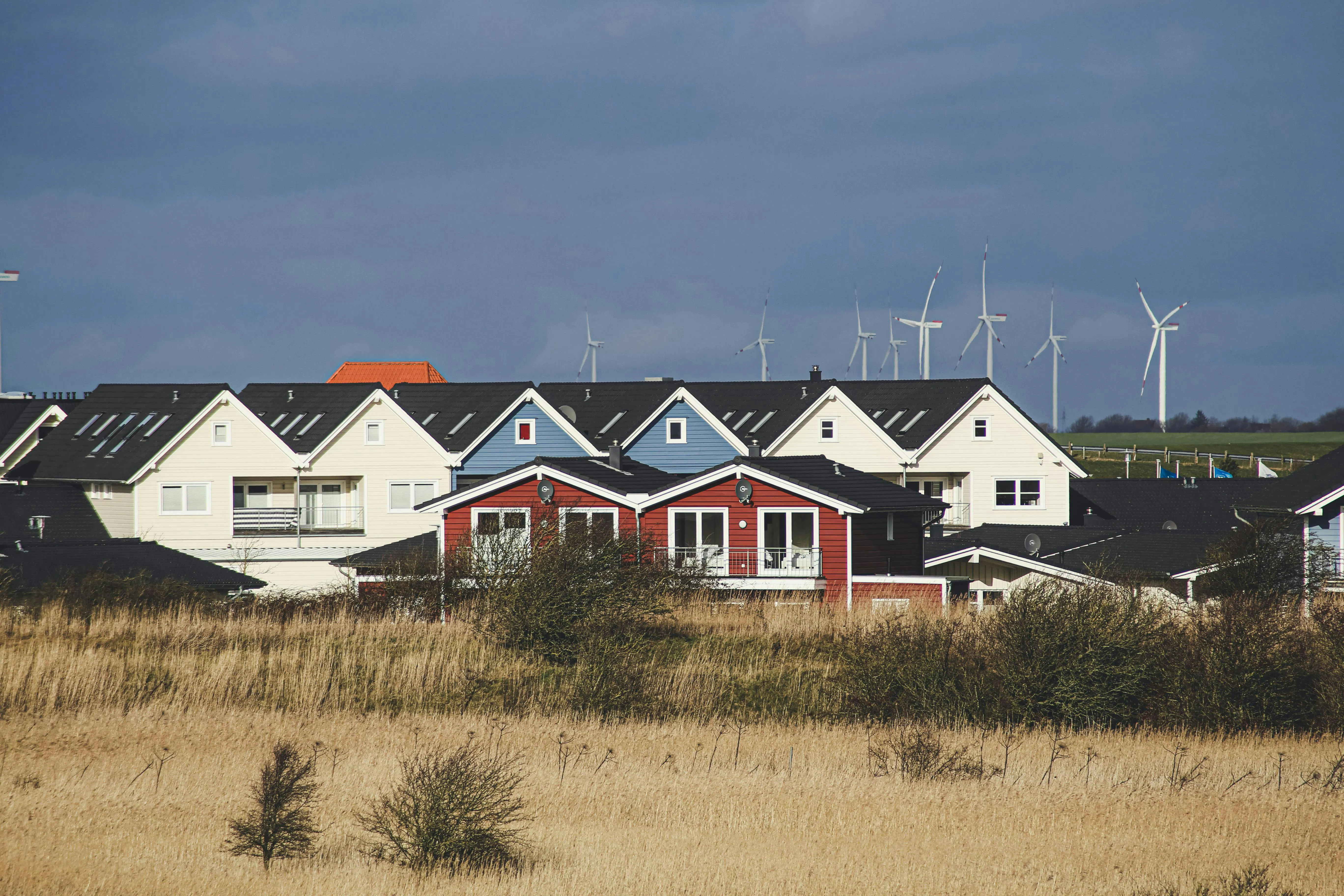 Homes with wind turbines in background