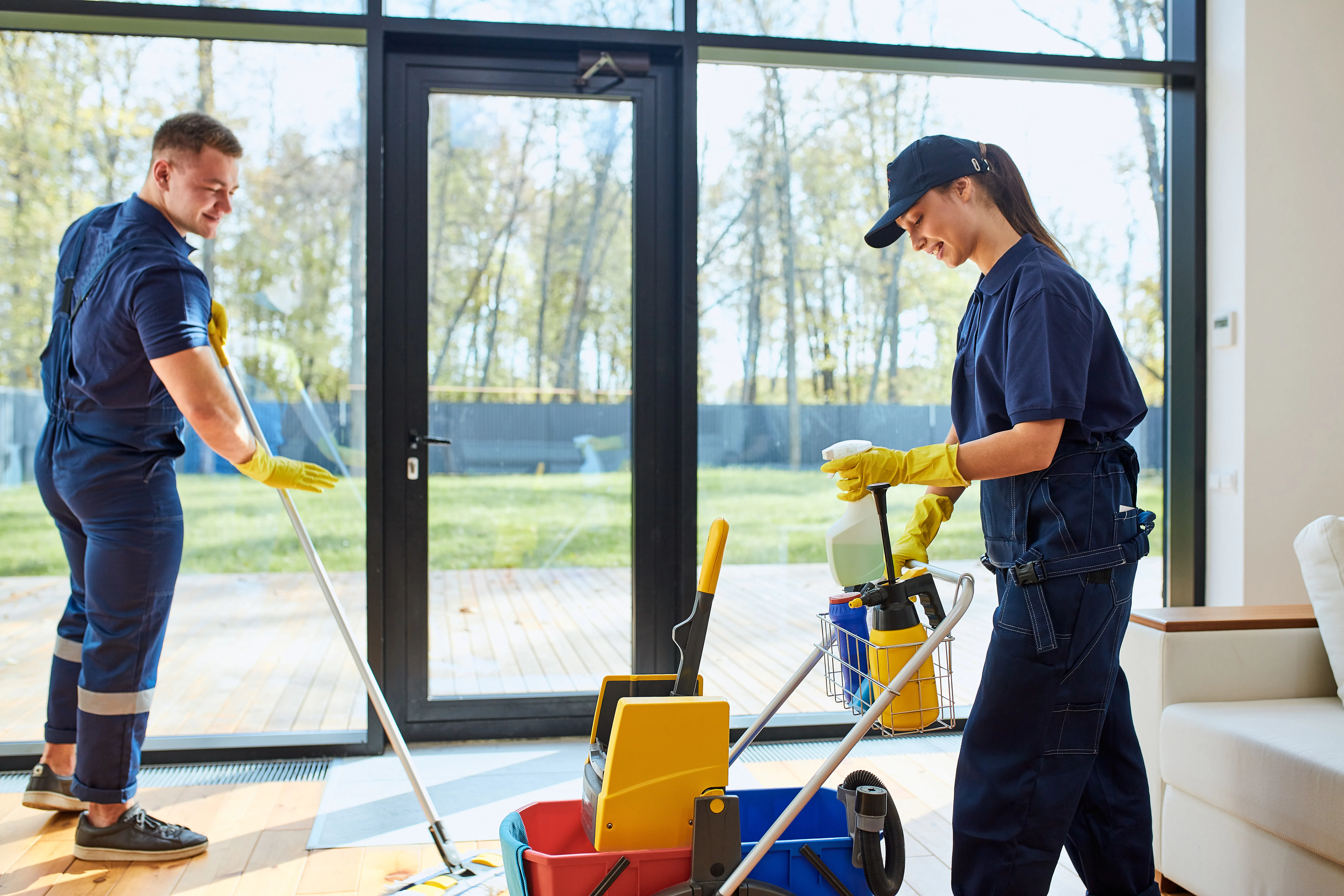 Two janitors clean country house with panoramic window, wash floors