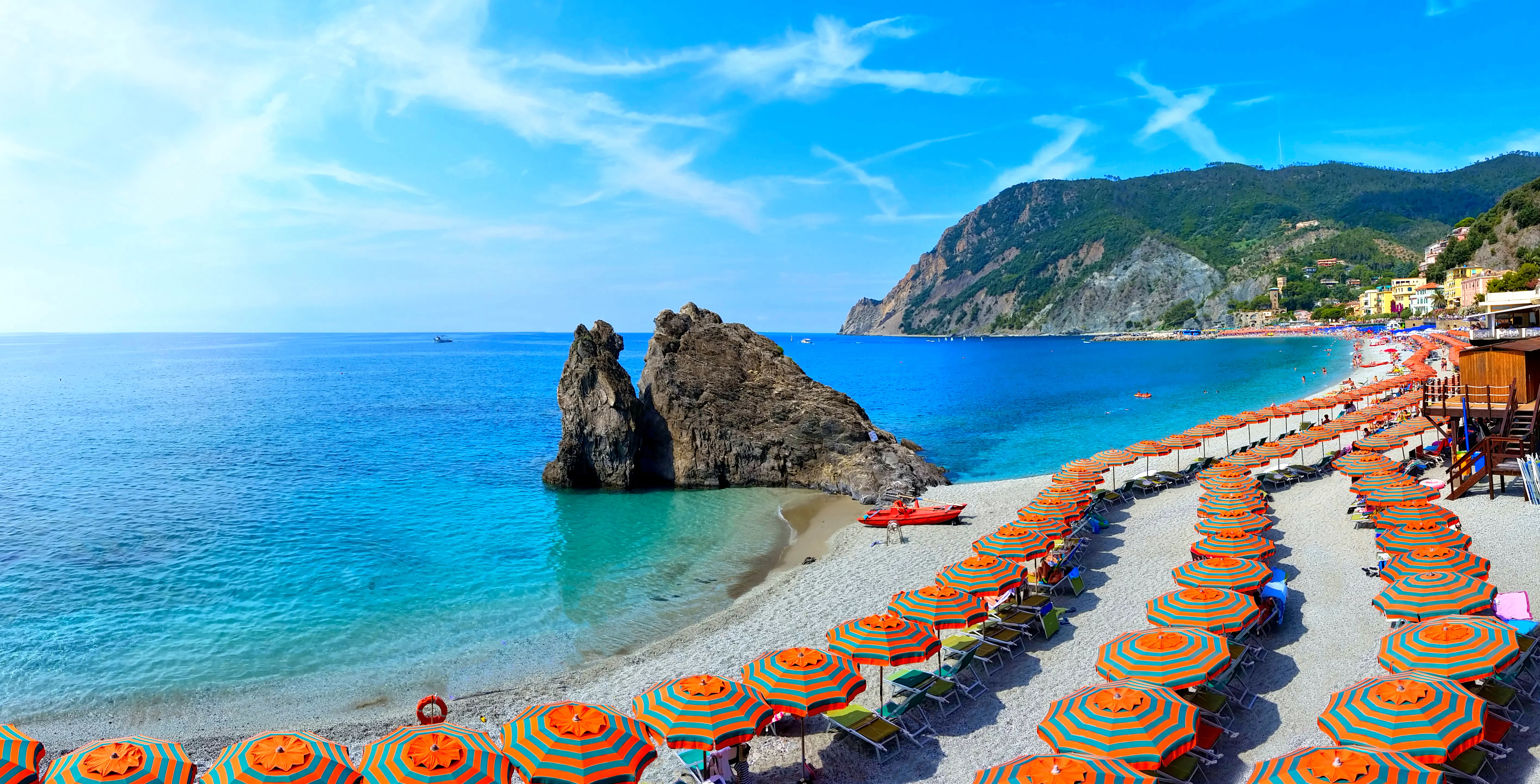 Panoramic view over colorful umbrellas at a beach in the Cinque Terre village of Monterosso