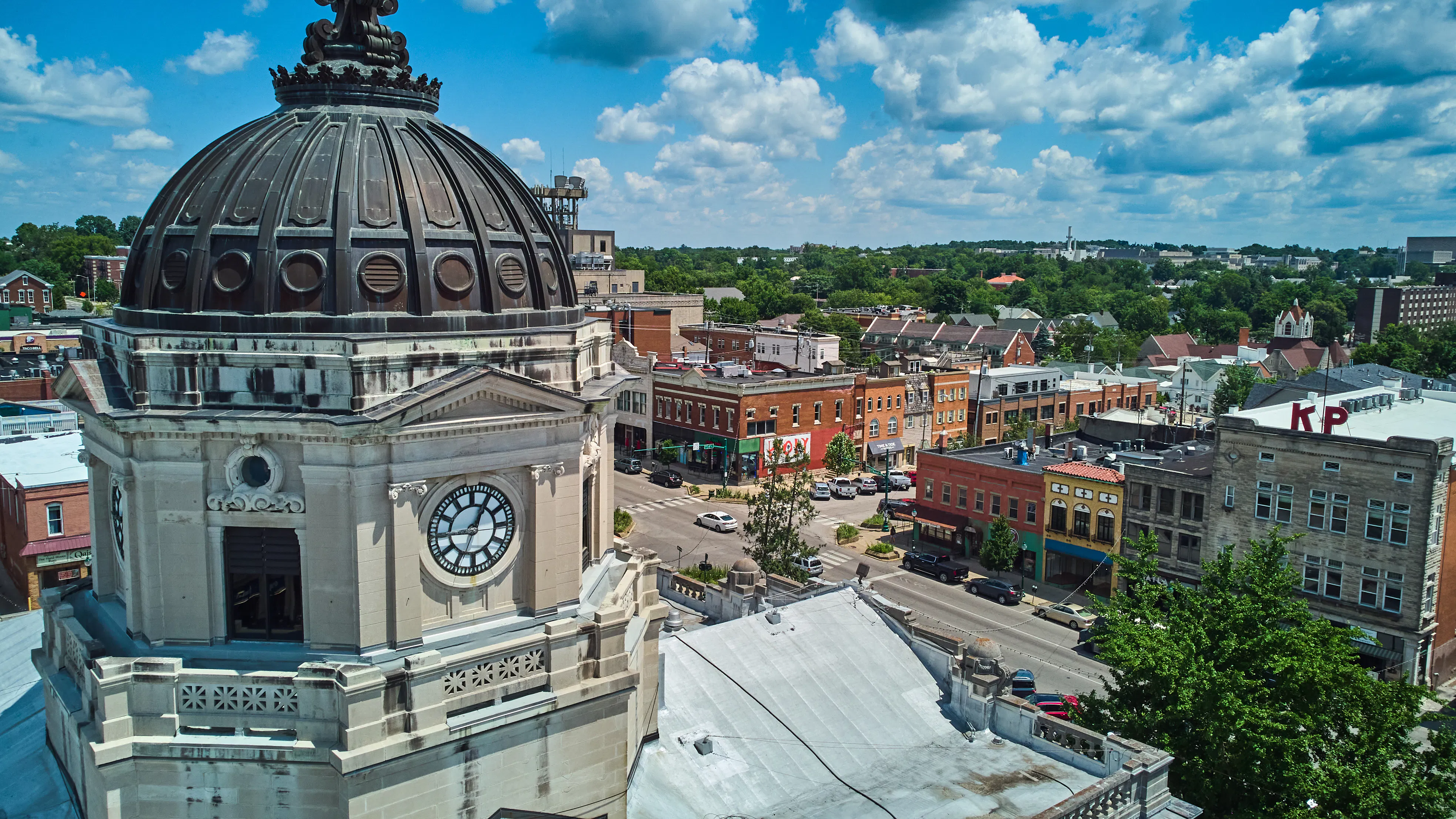 Up close to top of Bloomington Indiana courthouse clock with downtown in background
