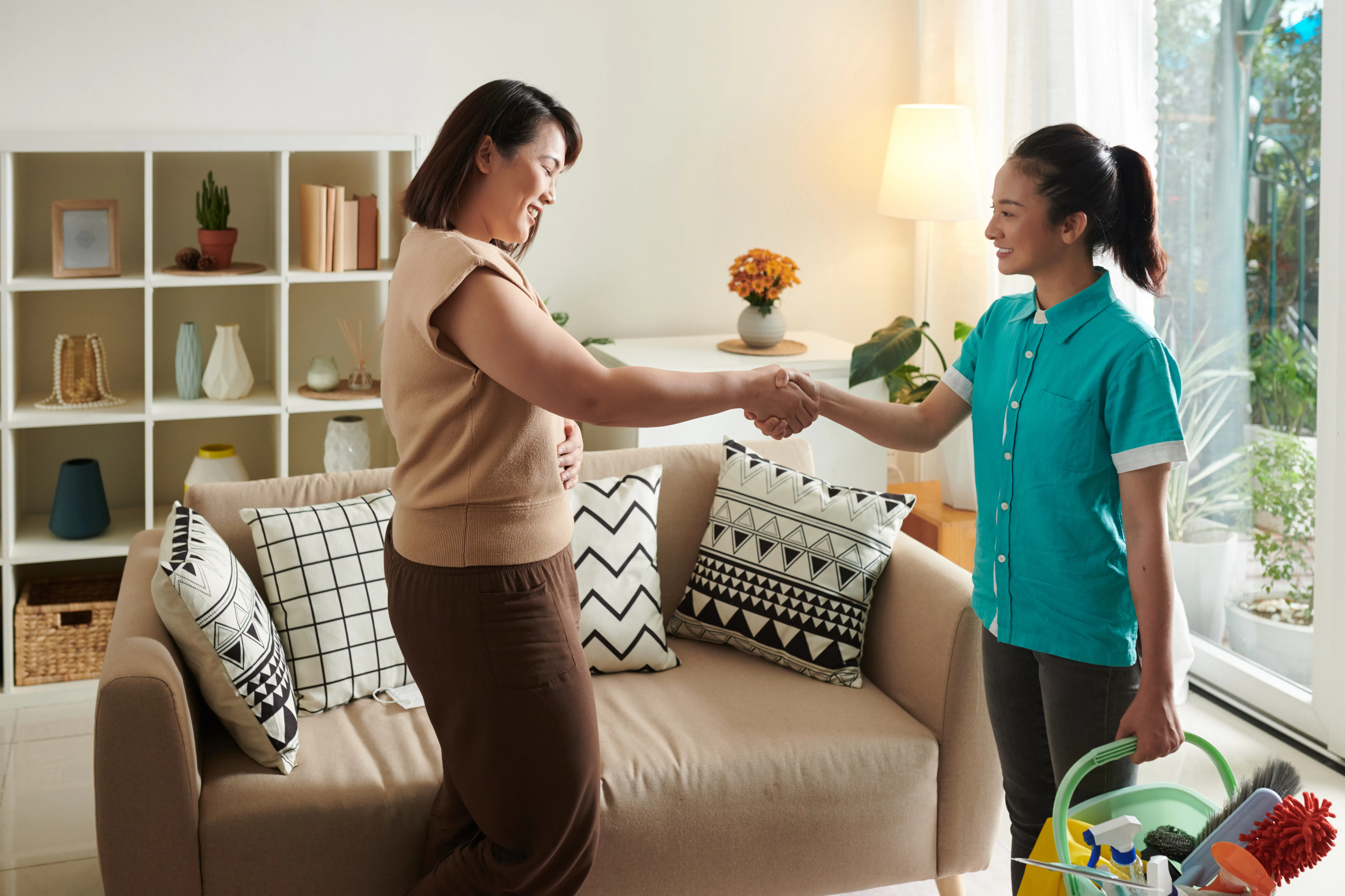 Homeowner shaking hands with cleaning lady