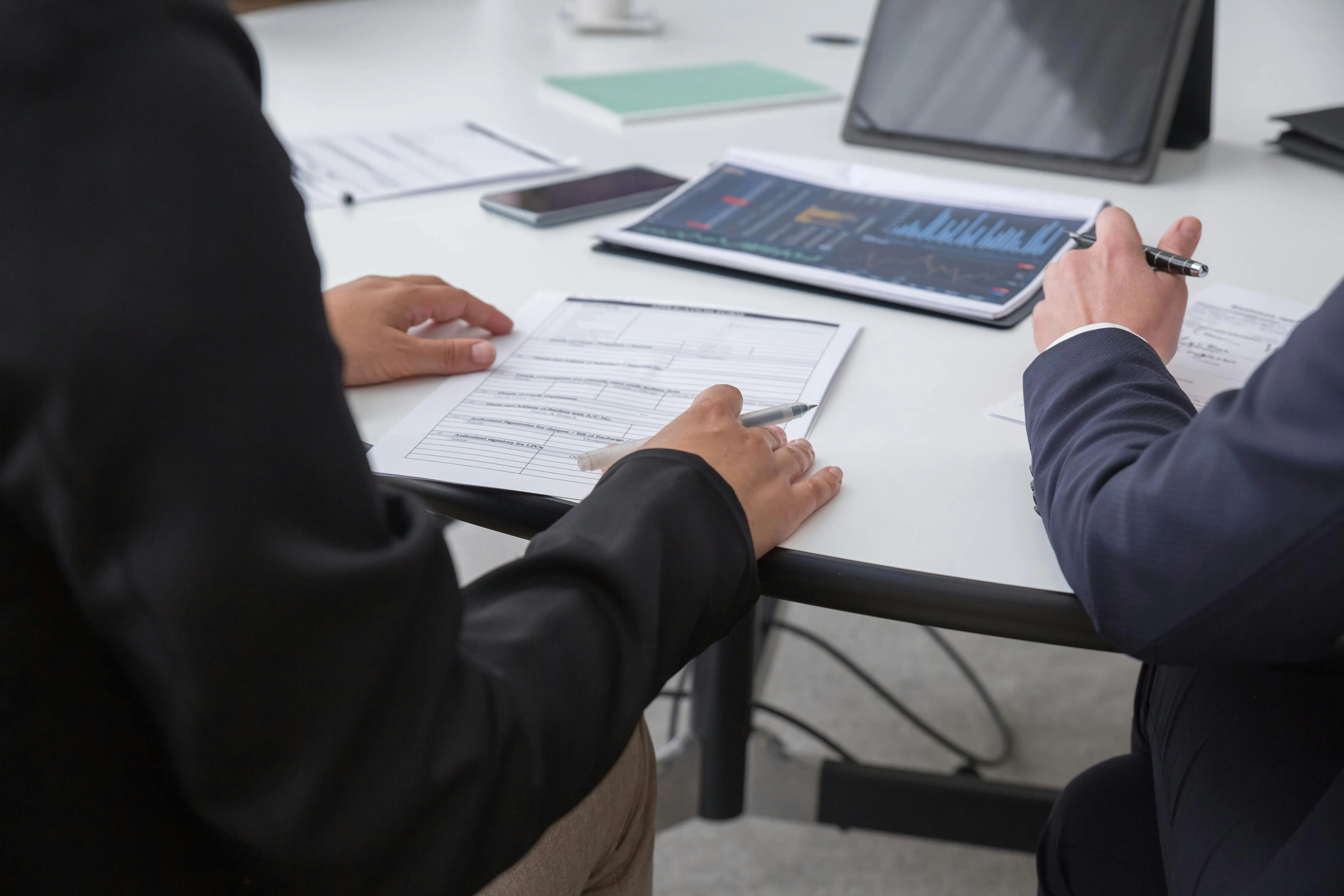 Réunion professionnelle examinant des documents de financement immobilier et des données d’investissement.