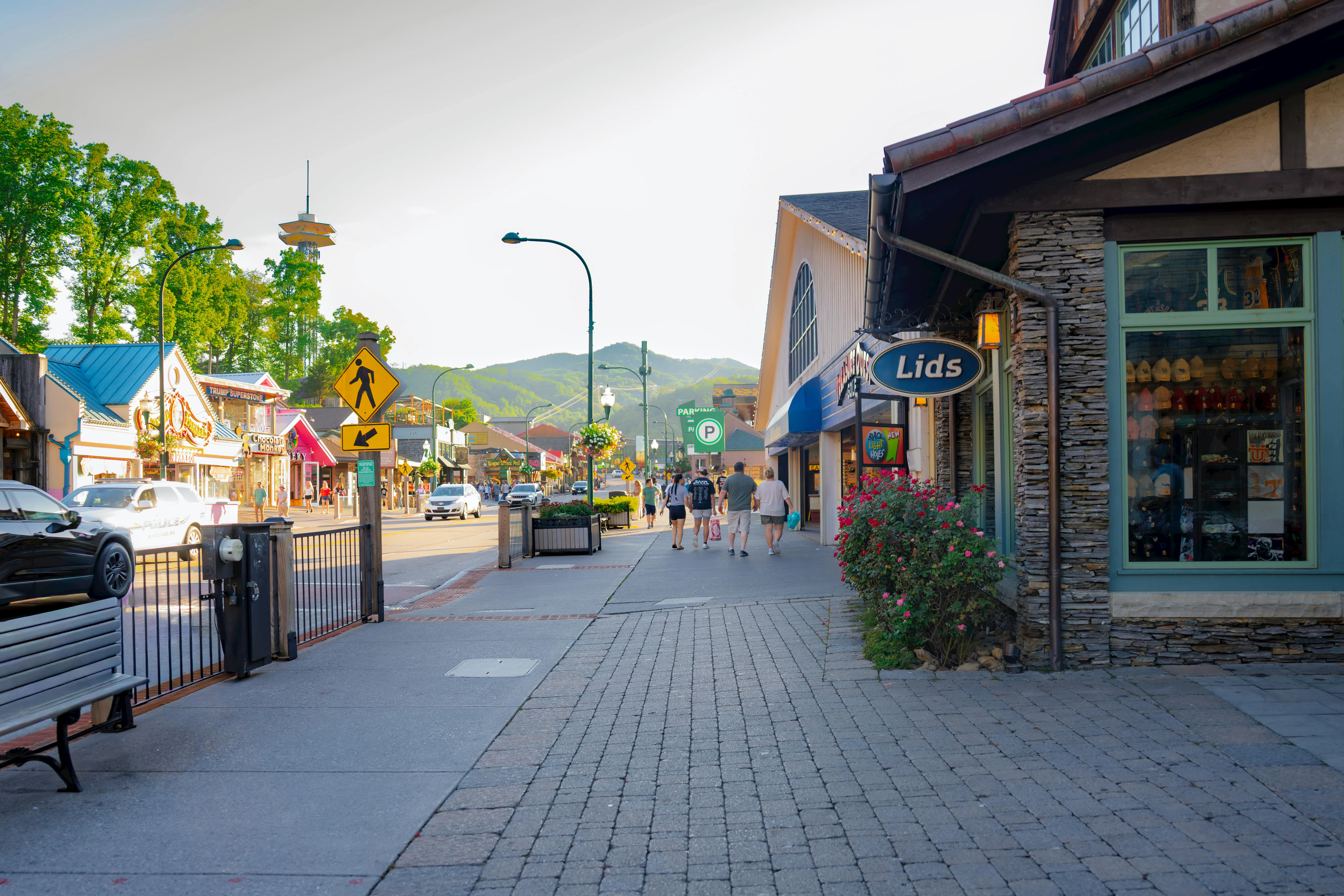 Gatlinburg, a shop-lined sidewalk with the Great Smoky Mountains in the distance