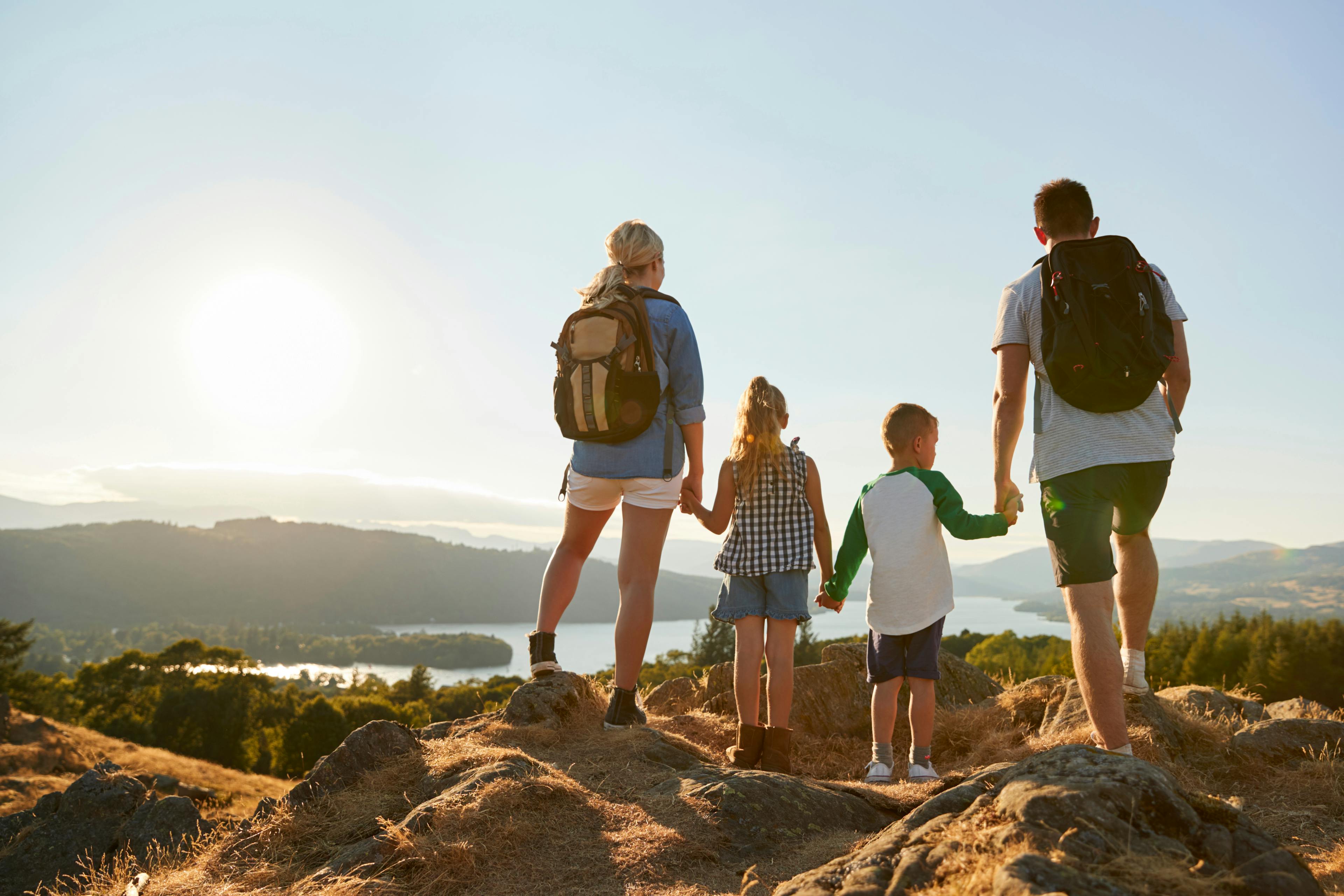 Rear View Of Family Standing At Top Of Hill On Hike