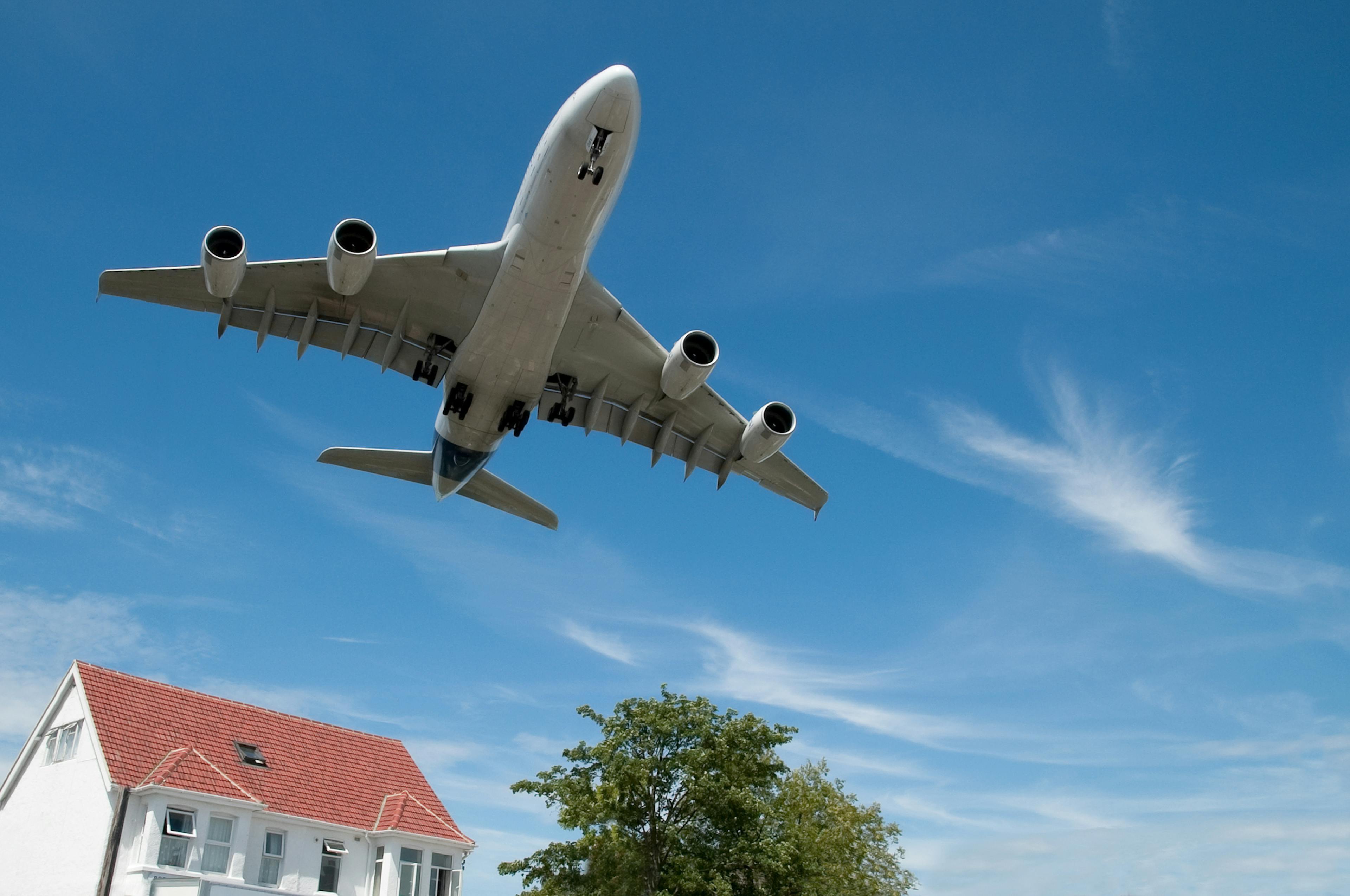 large jet aircraft on landing over suburban housing