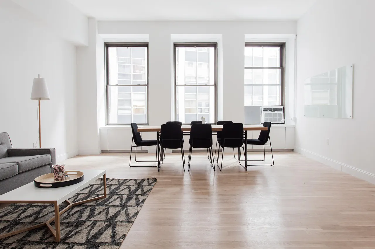 A minimalist, modern dining area with light wood floors