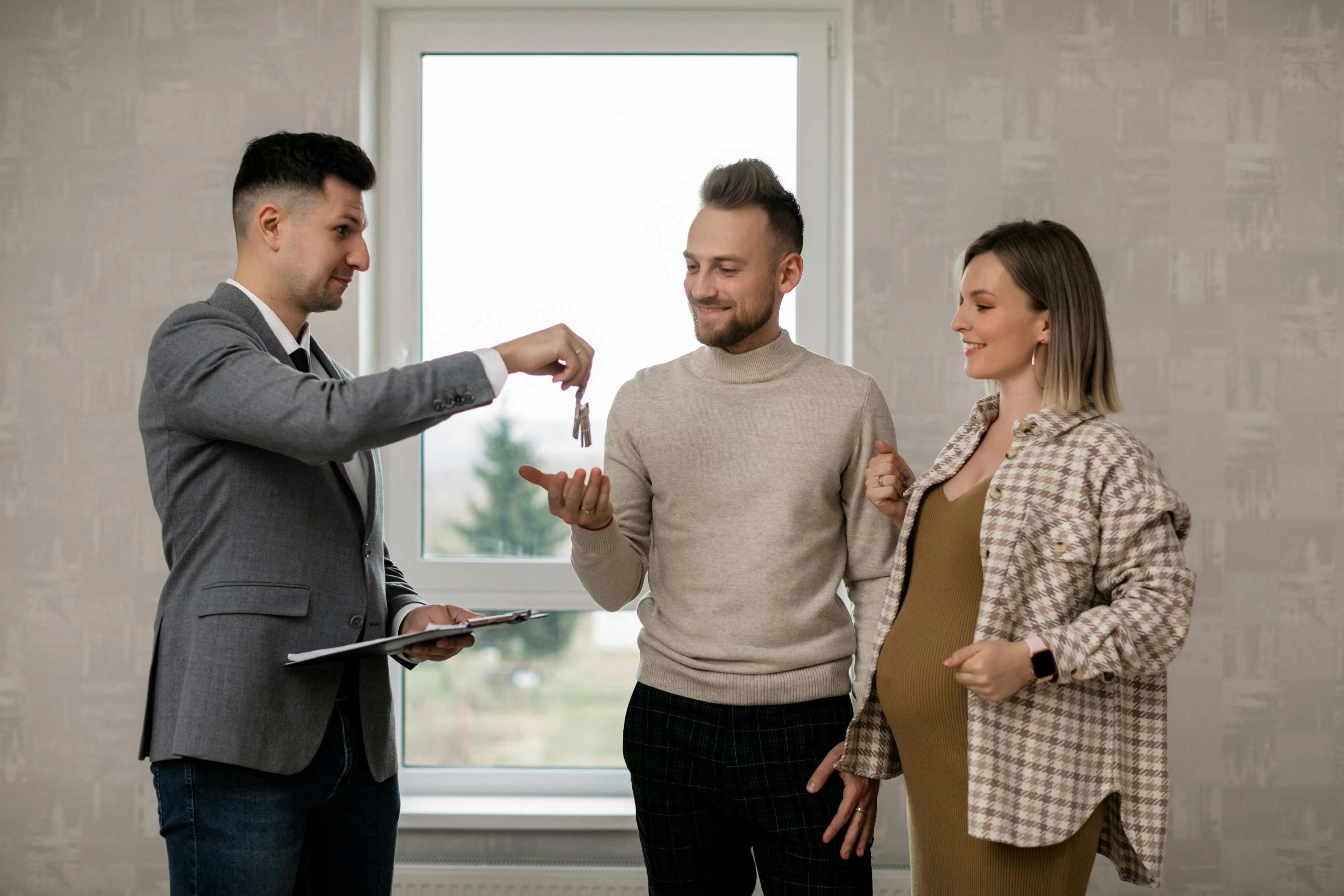 Real estate agent handing keys to couple