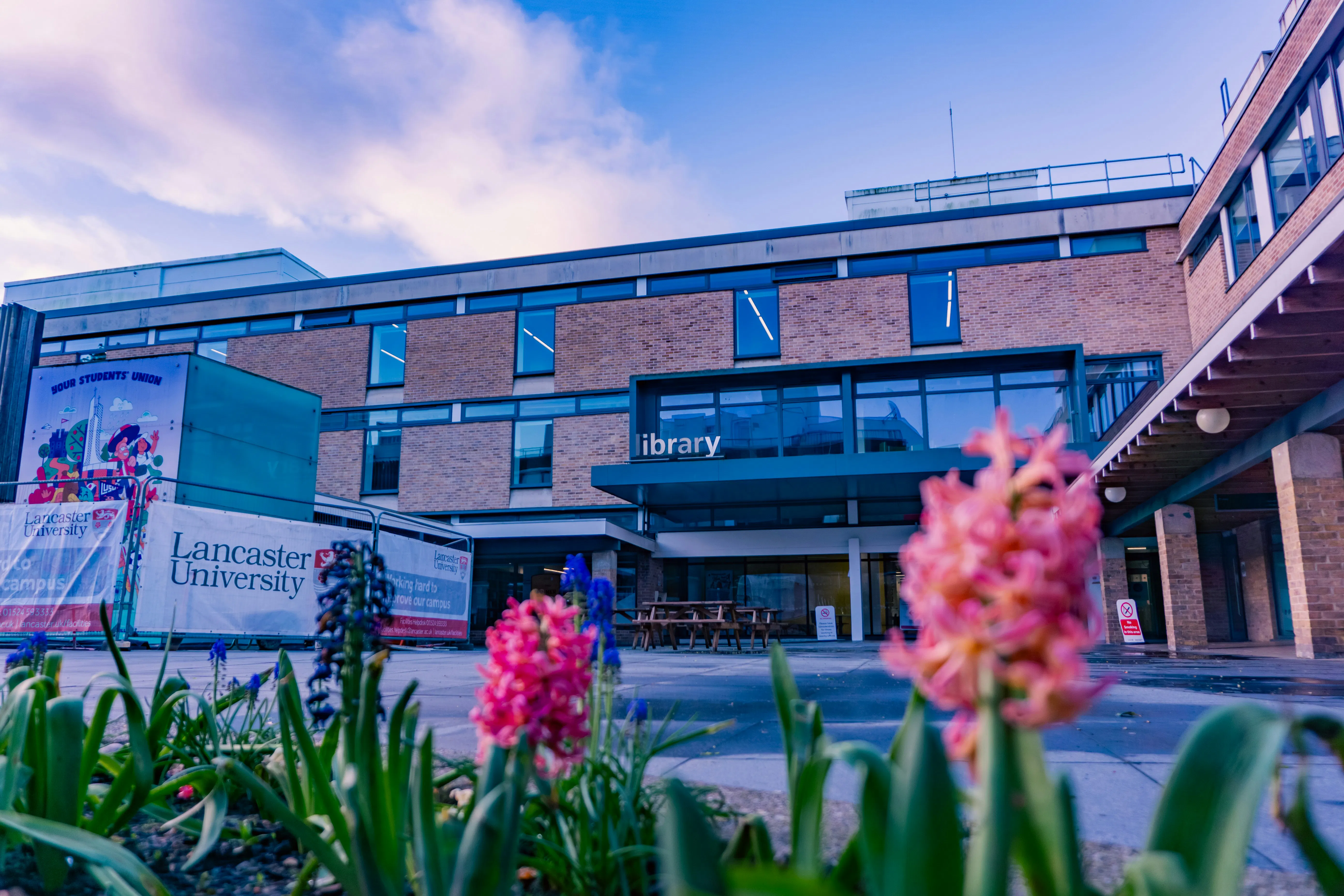 Lancaster University library behind pink flowers