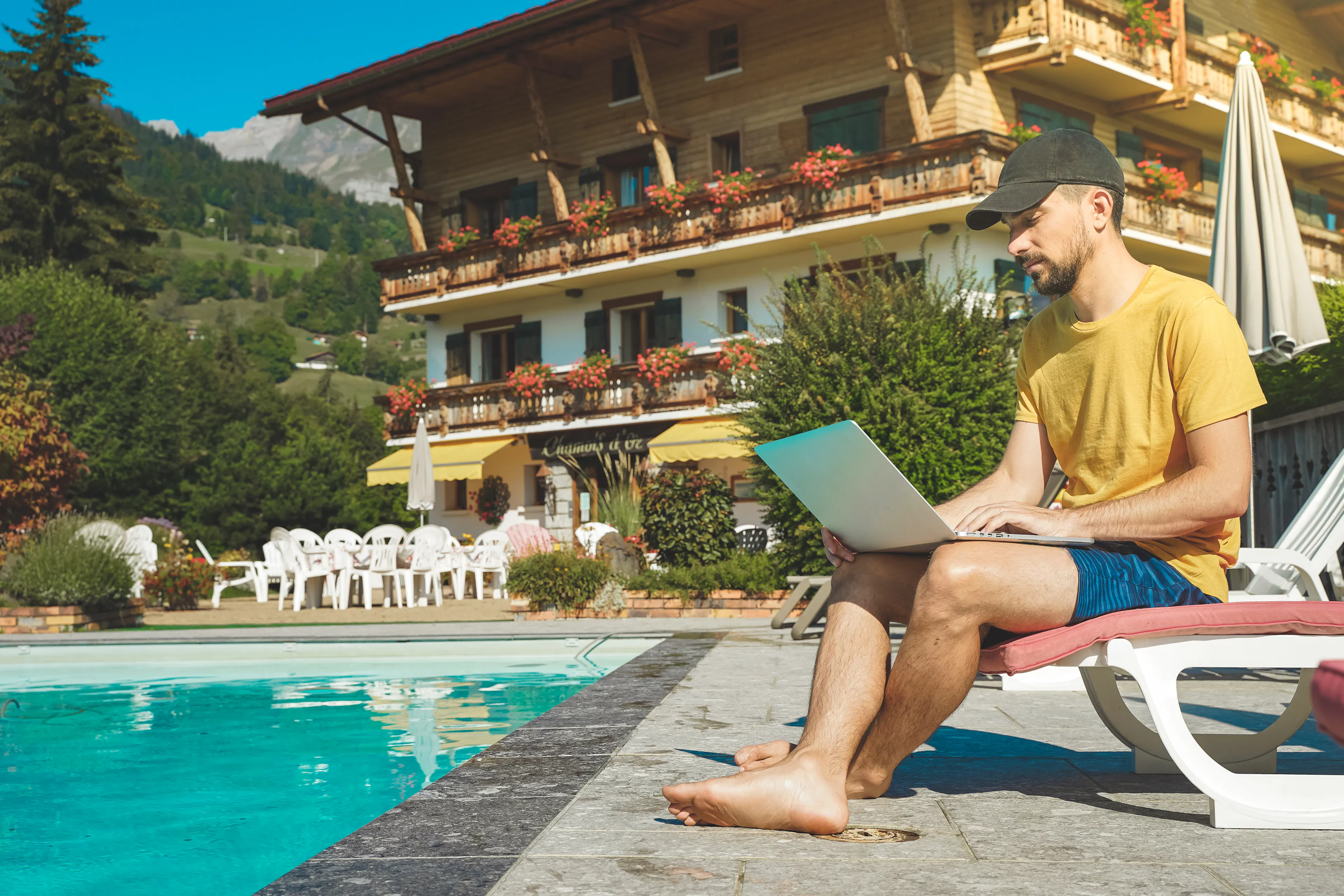 Man Works on Laptop by a Tranquil Pool
