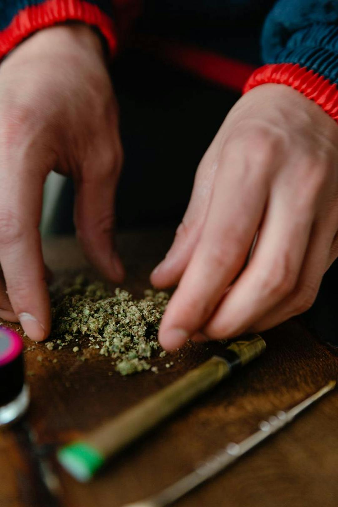 Man's hands rolling up a joint