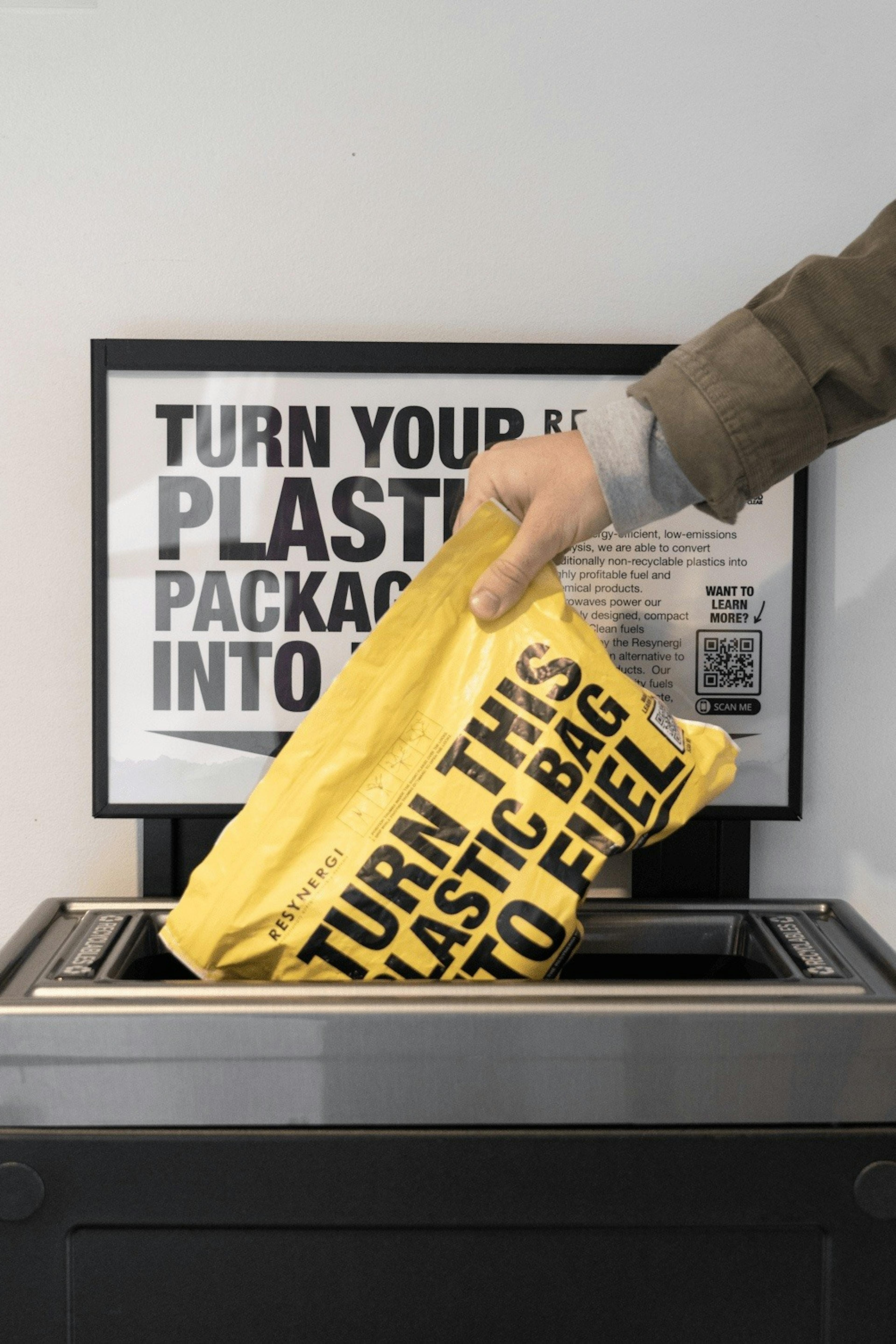 Person throwing away bag of trash