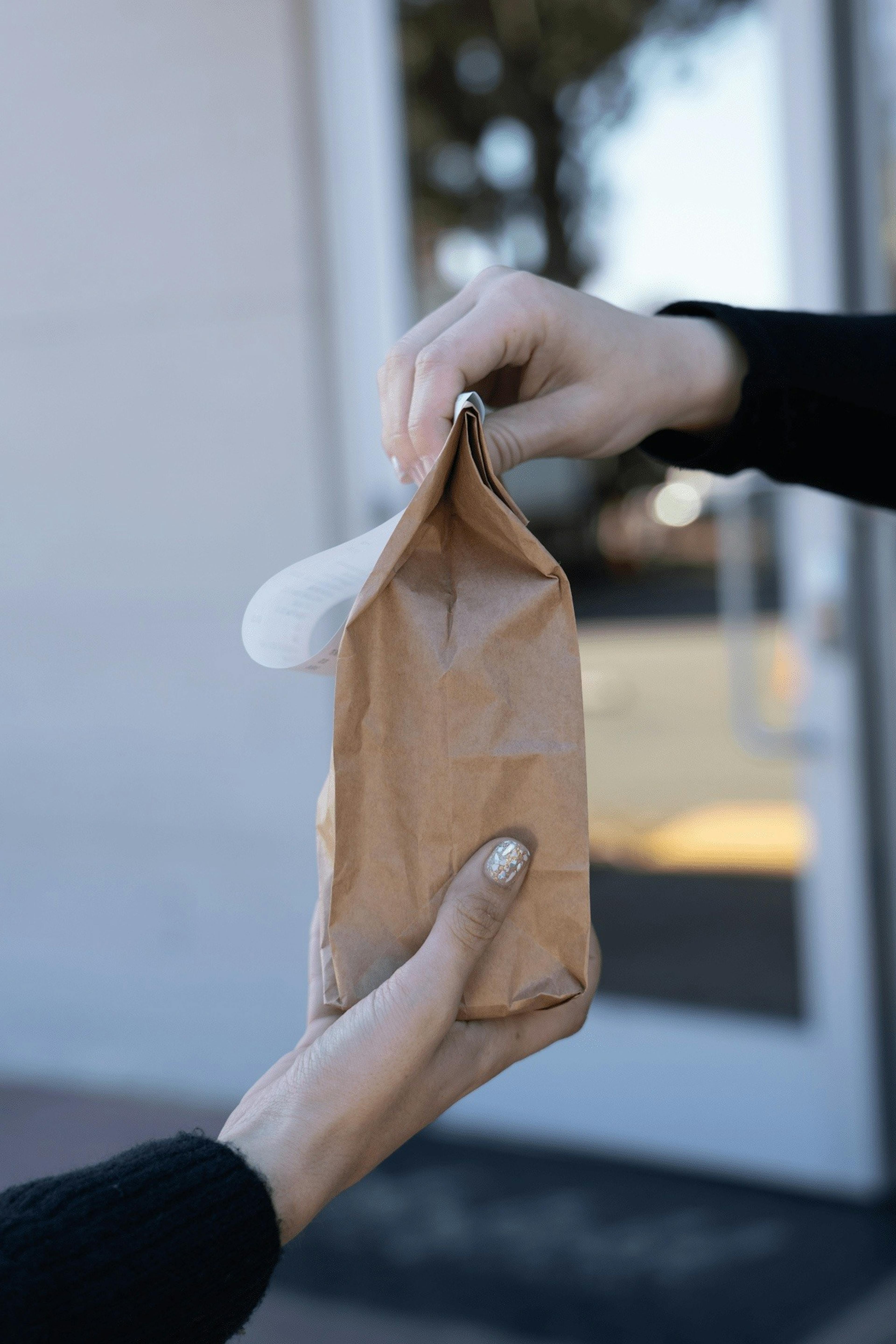 Budtender handing of bag of products to customer