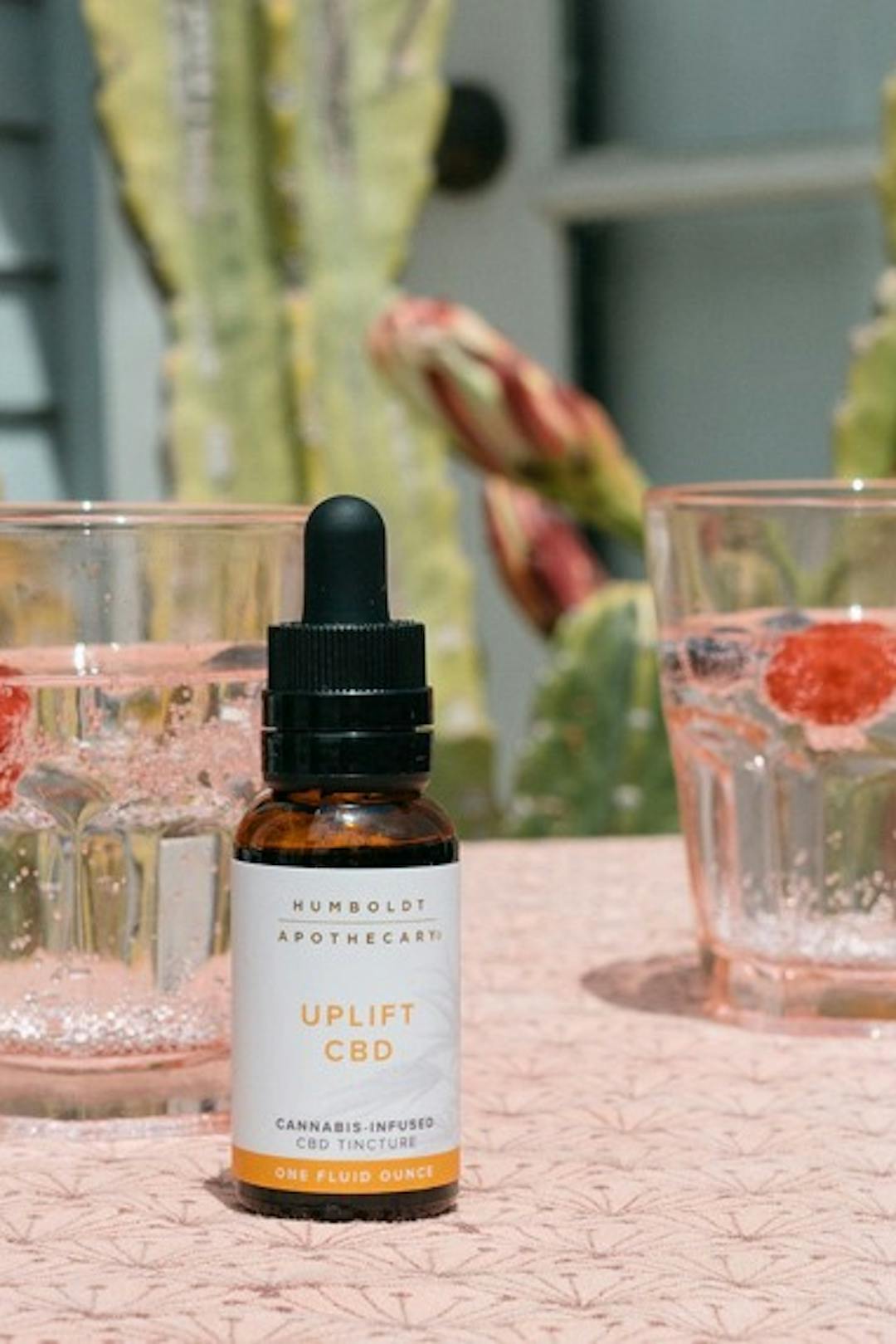 A tincture on a table next to two glasses