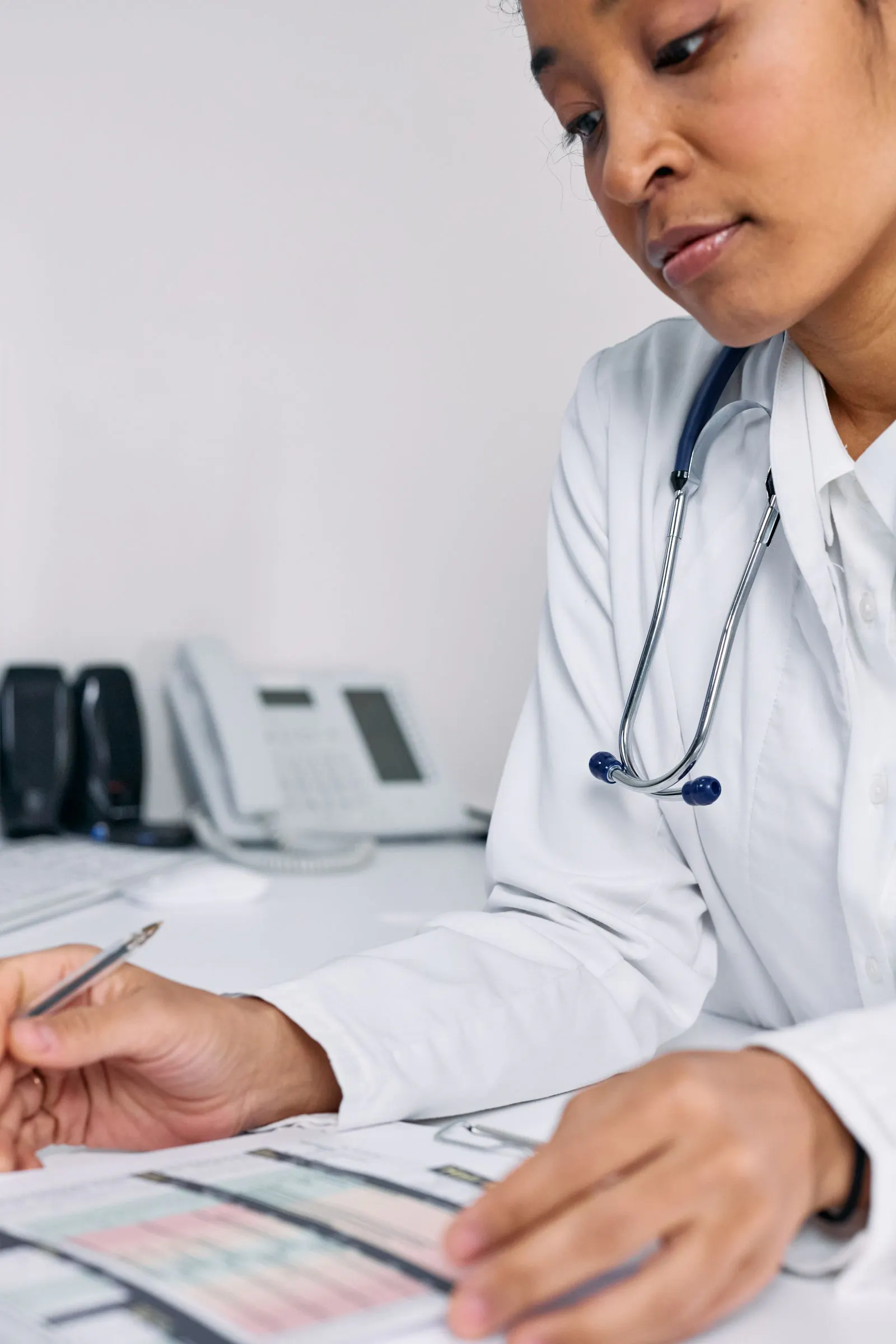 Doctor reviewing patient medical records at a desk