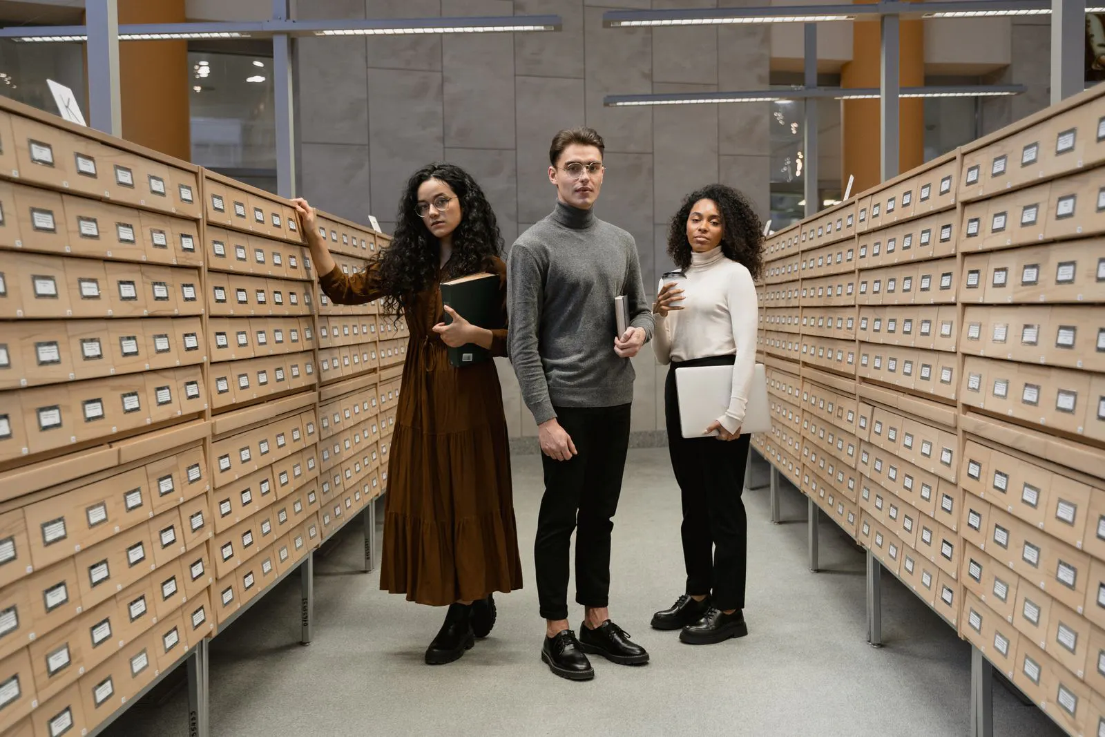 Two college students standing between rows of student records archive drawers