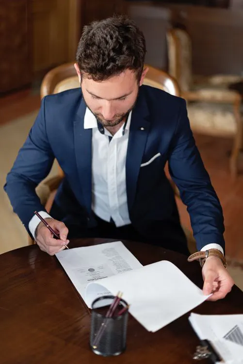 Government official signing documents at a desk, representing electronic signature workflows in public sector agencies