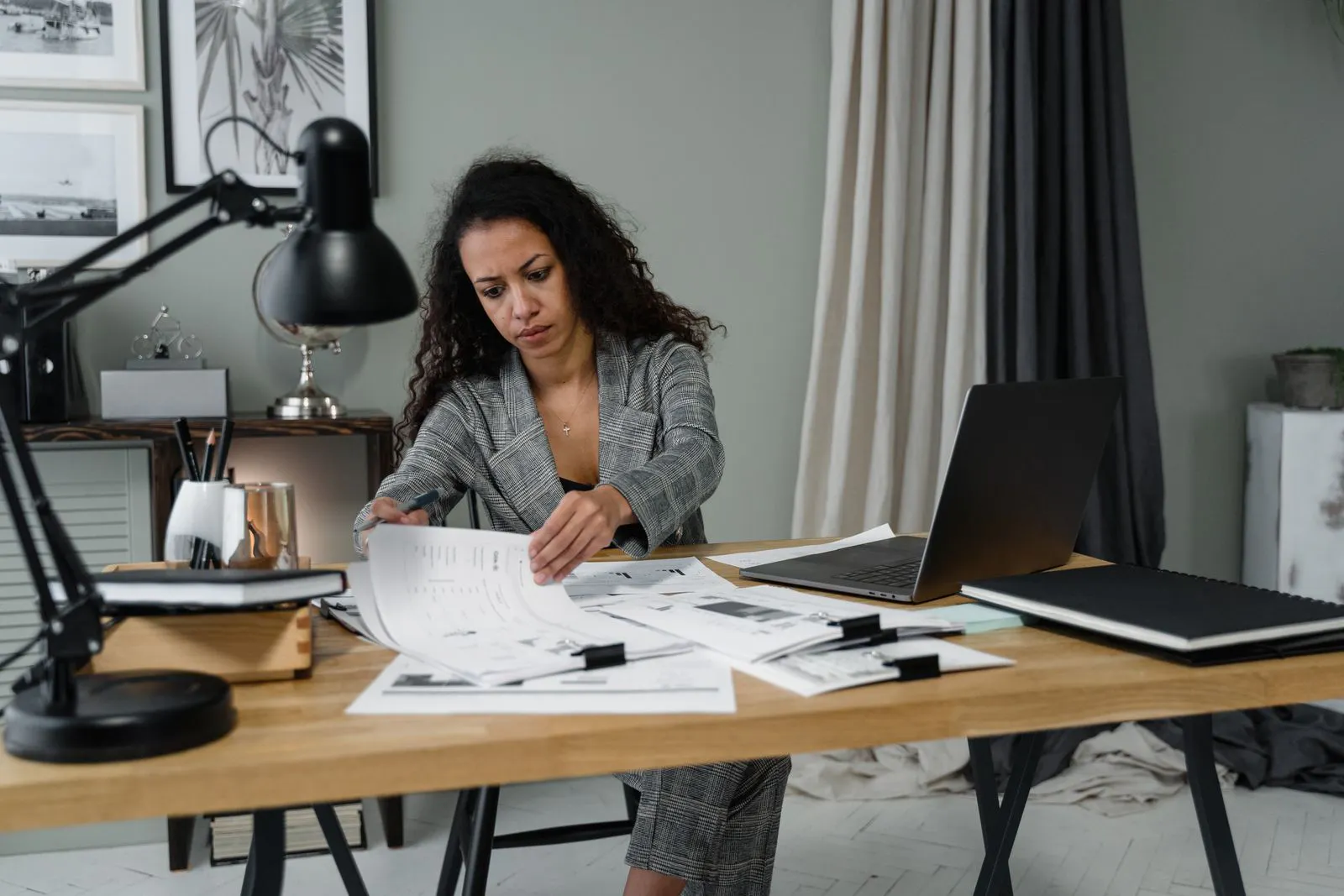 Businesswoman reviewing government compliance documents at desk