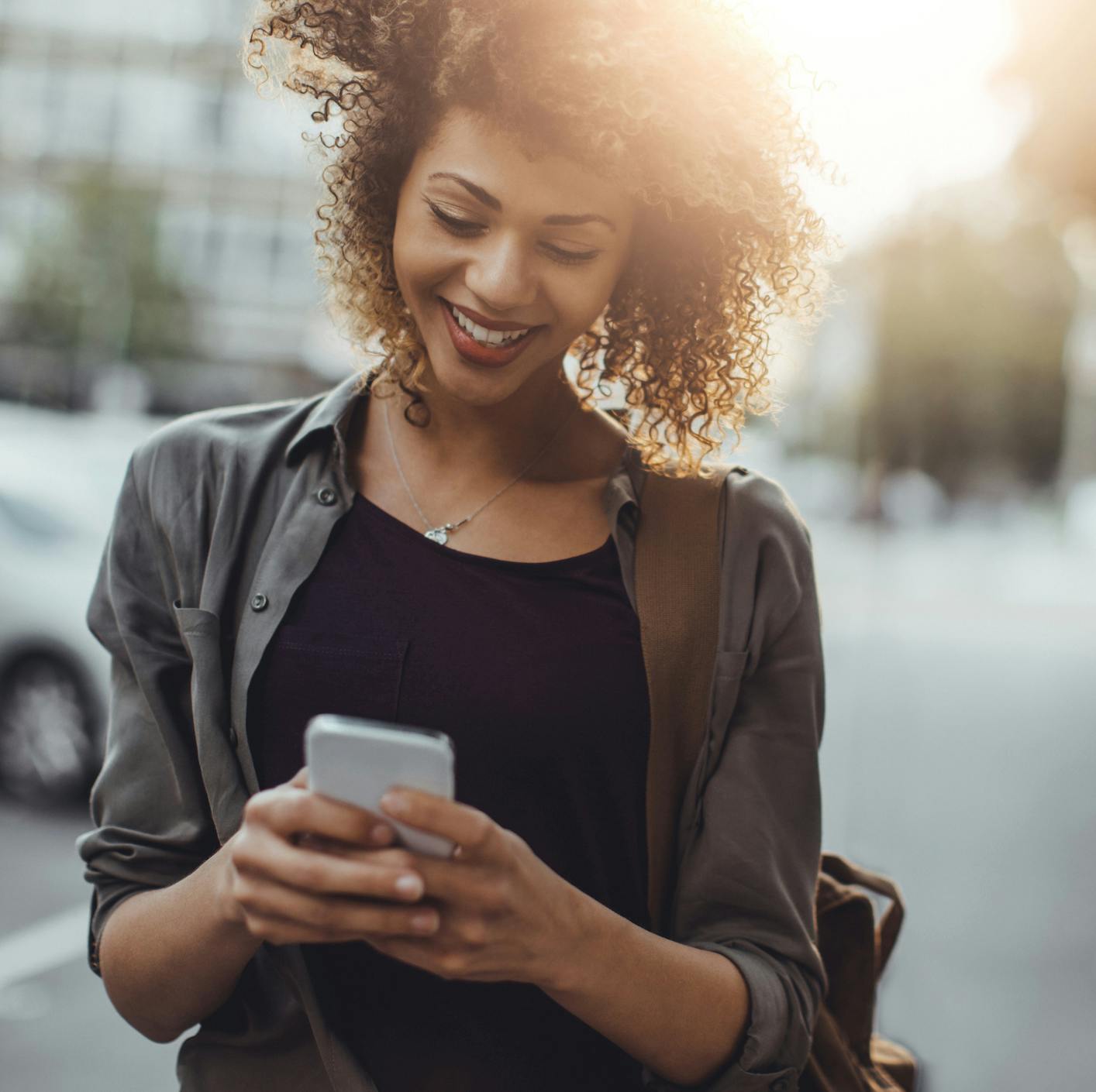student engaging with her phone while outside