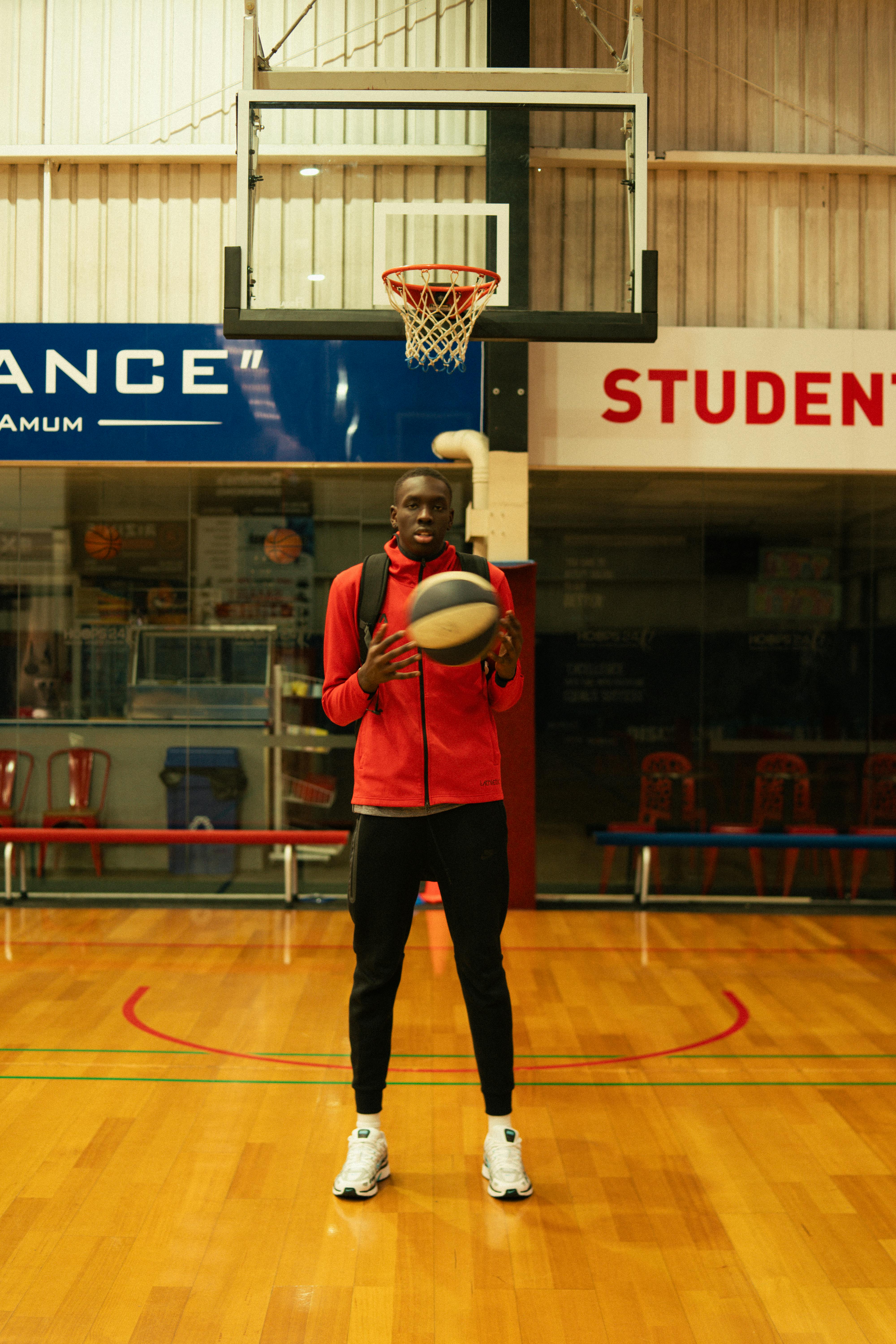Mangok holding a basketball on court