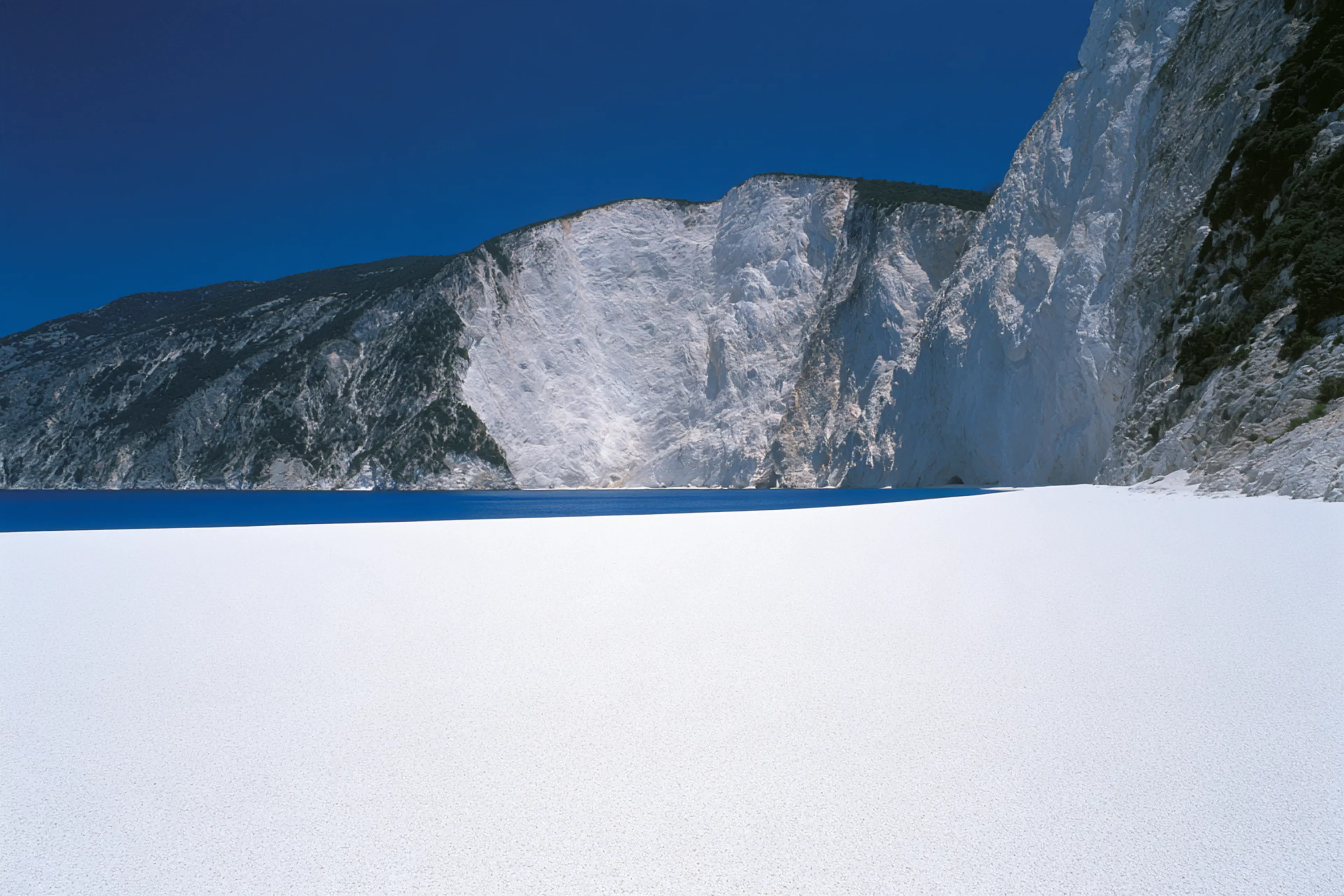 paysage plage blanche et massif rocheux
